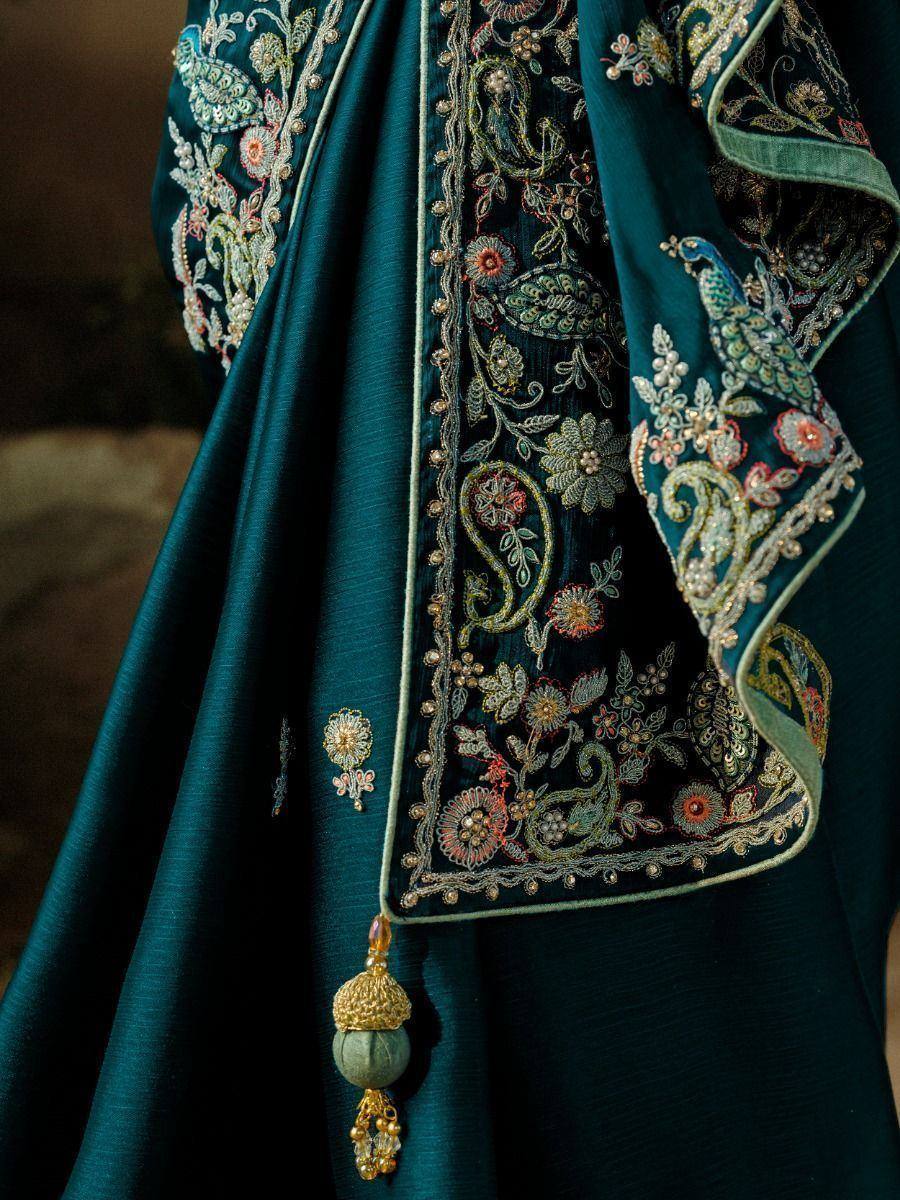 Emerald green embroidered lehenga choli with floral and peacock motifs, gold tassels, and intricate detailing