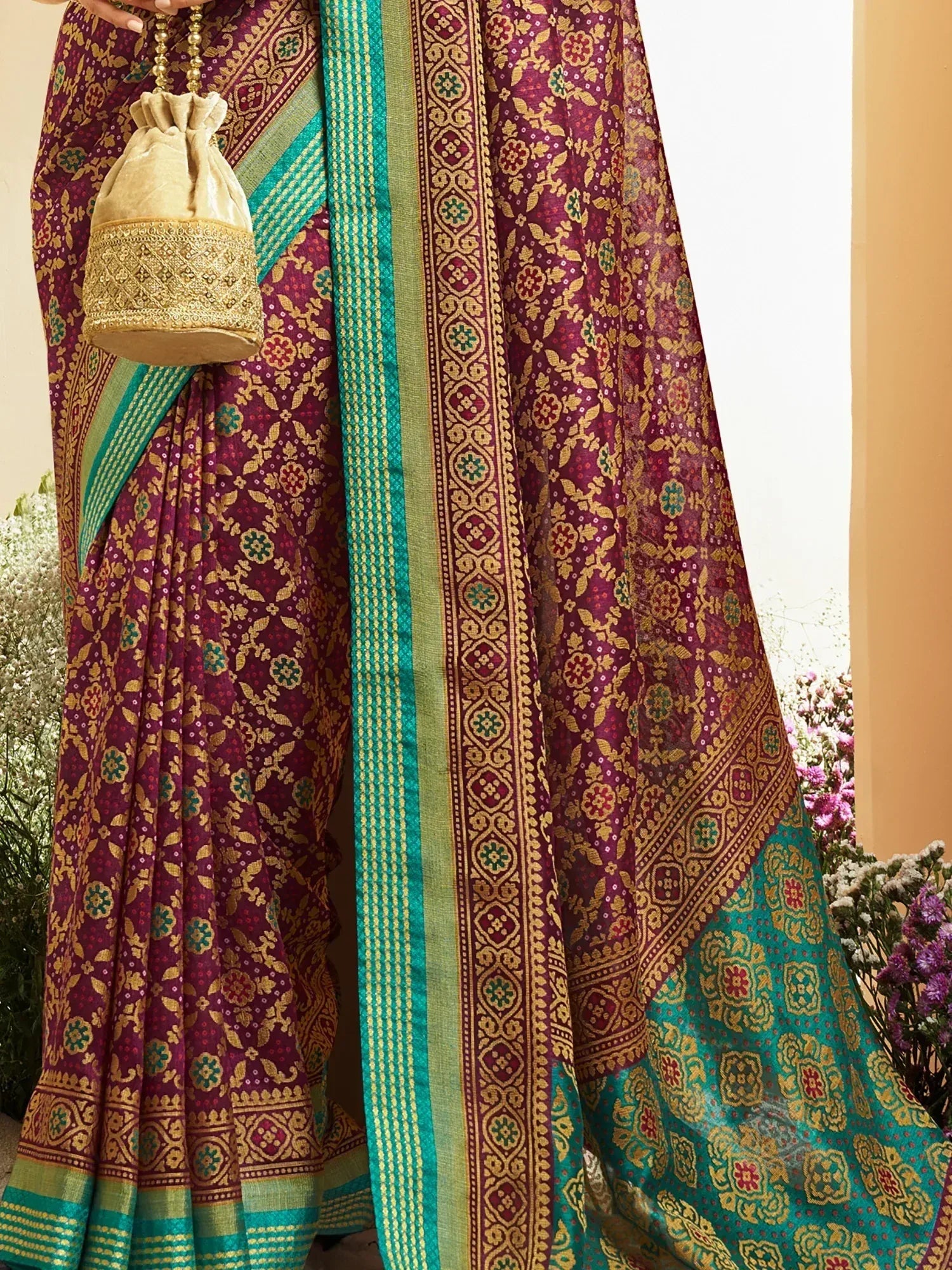 Elegant maroon and teal saree with intricate gold floral patterns and border design