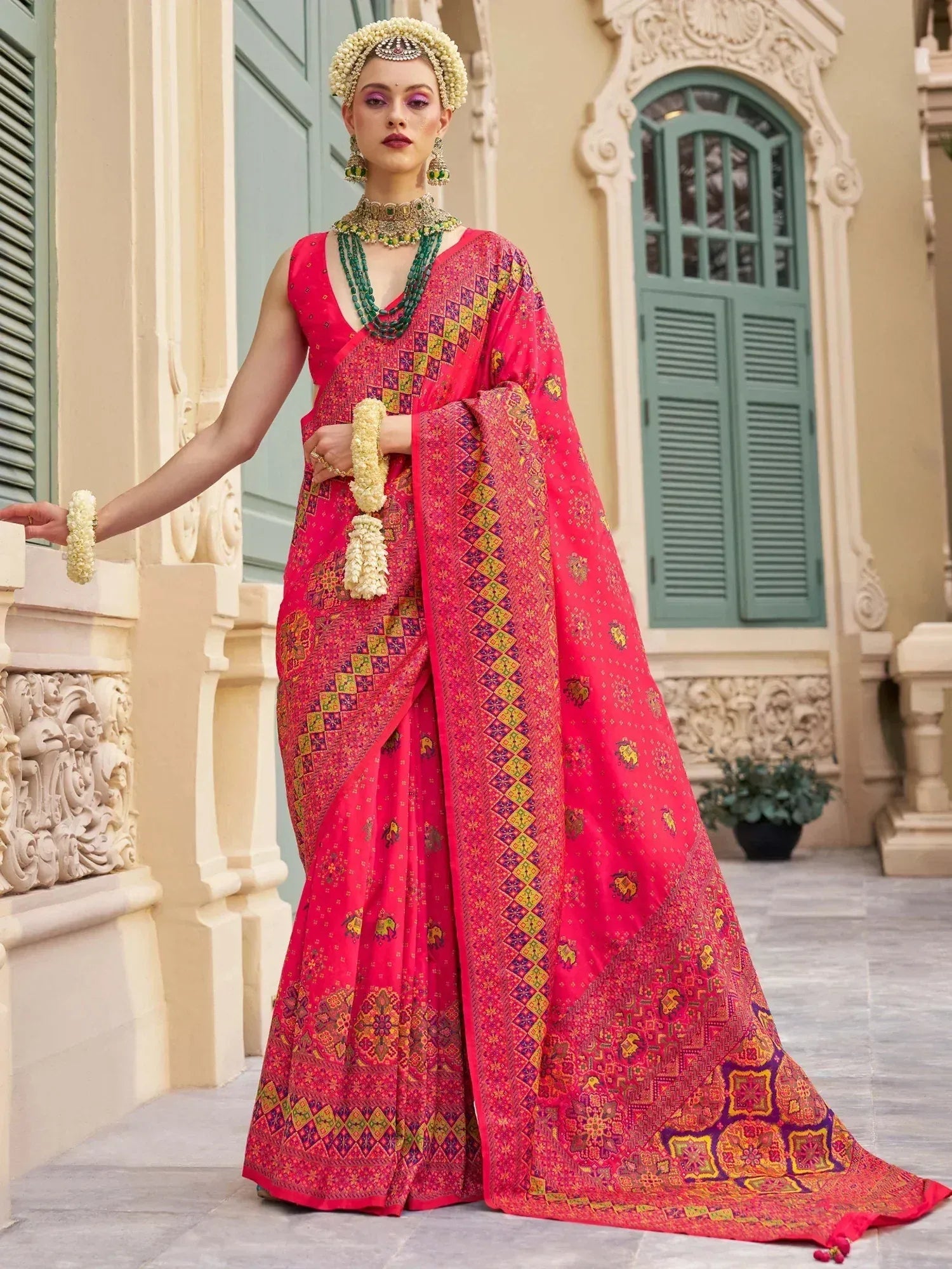 Vibrant pink printed saree with ethnic jewelry, perfect for Indian weddings and festive occasions