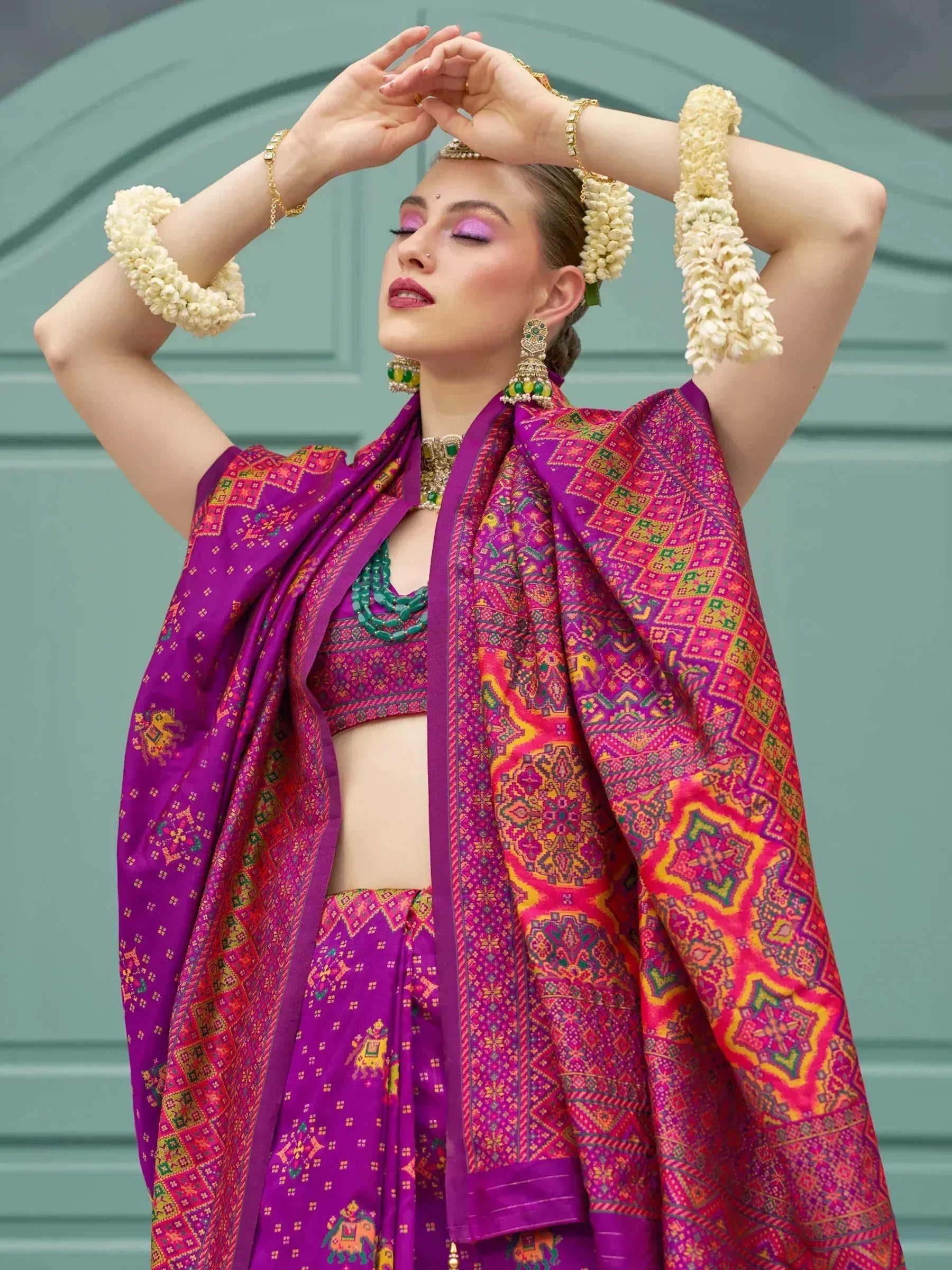 Vibrant purple lehenga choli with intricate embroidery, floral garlands, and traditional jewelry for Indian ethnic wear.