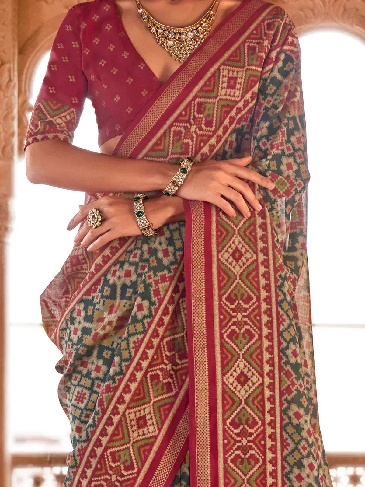 Indian ethnic saree with intricate geometric print, paired with matching blouse and traditional jewelry