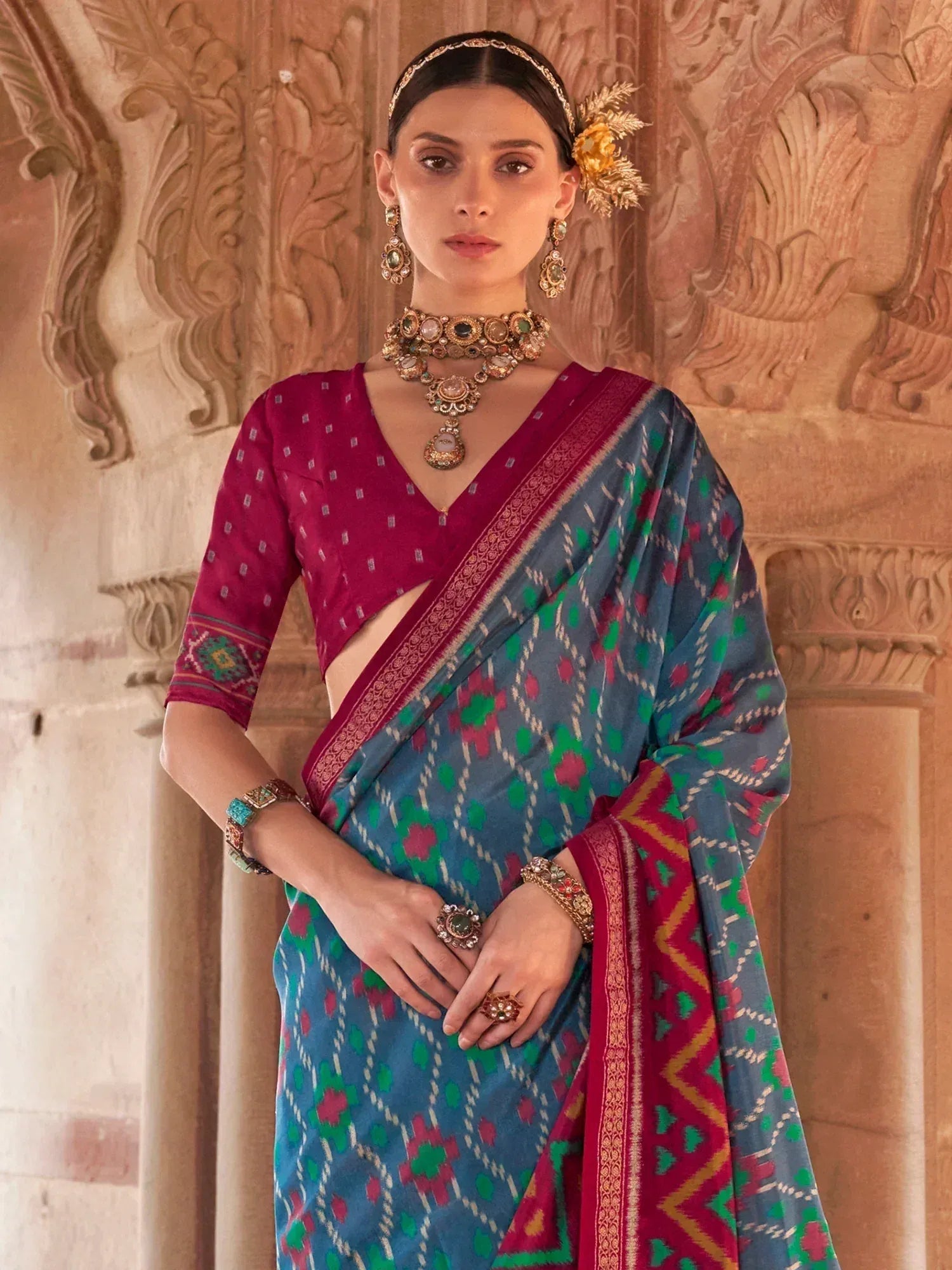 Woman in blue and pink ikat saree with ethnic jewelry, traditional Indian attire