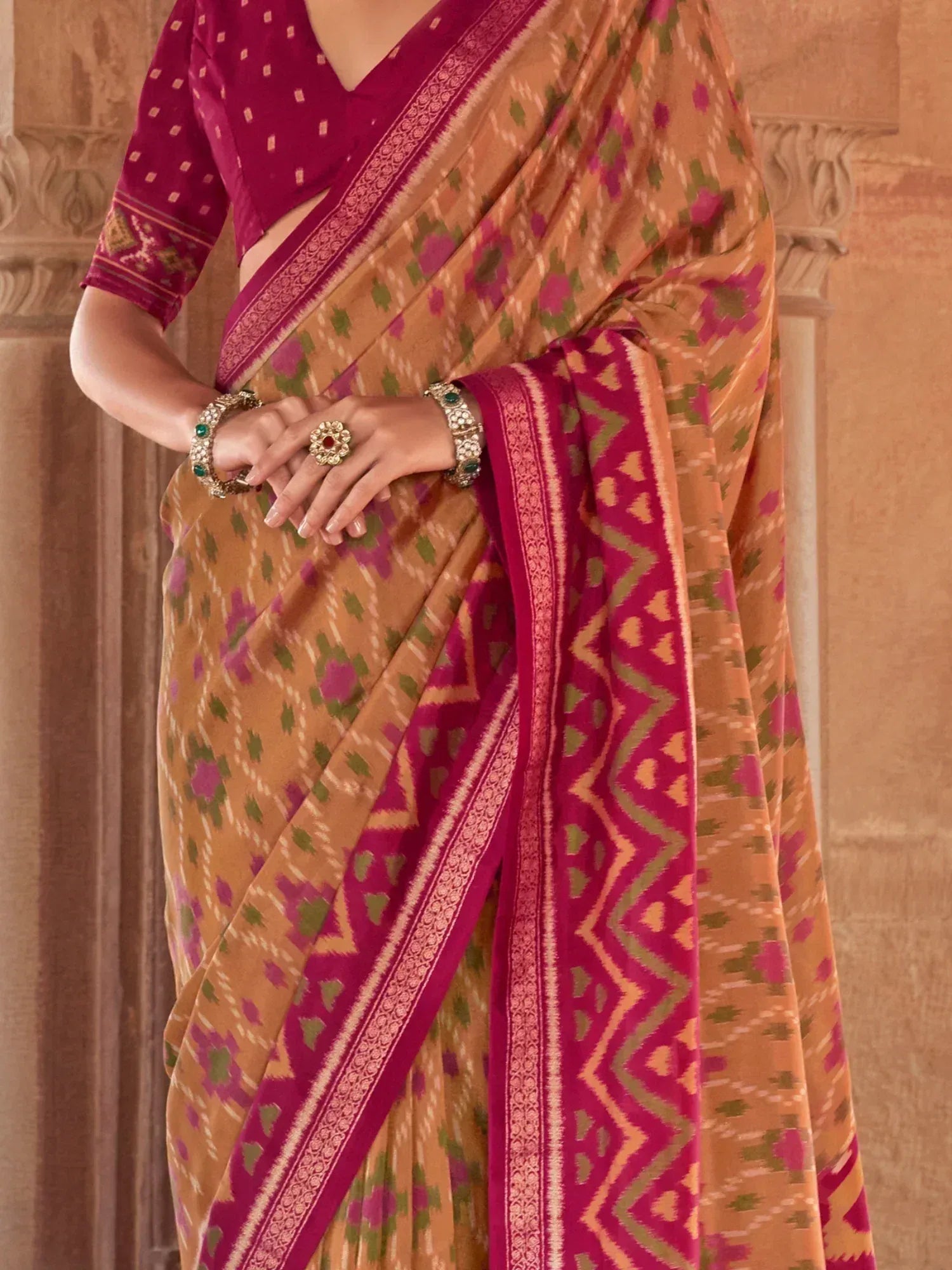 Woman in vibrant Ikat saree with magenta blouse, floral and geometric patterns, traditional Indian ethnic wear