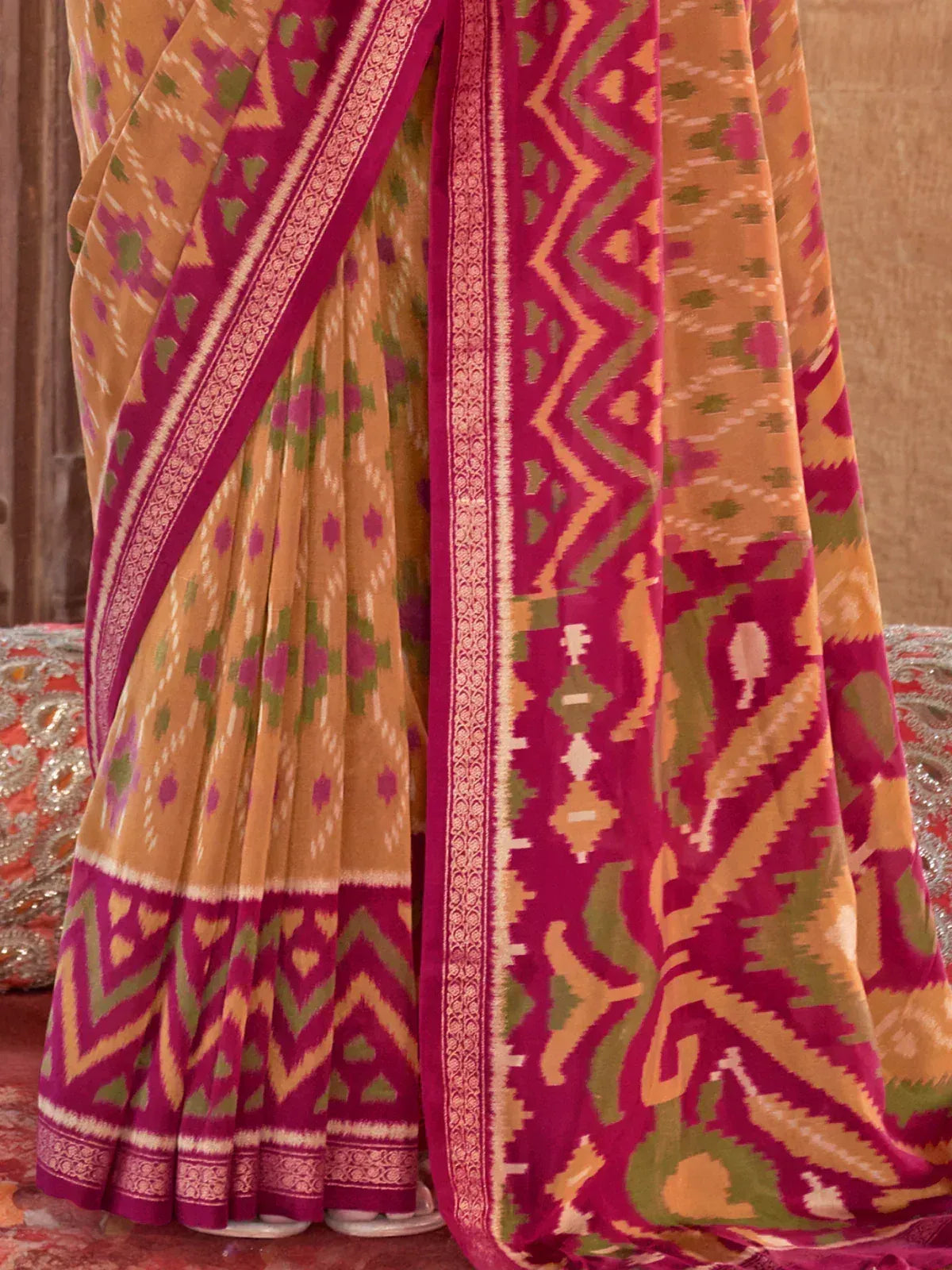 Vibrant Ikat saree with geometric patterns in mustard, magenta, and green, perfect for ethnic occasions