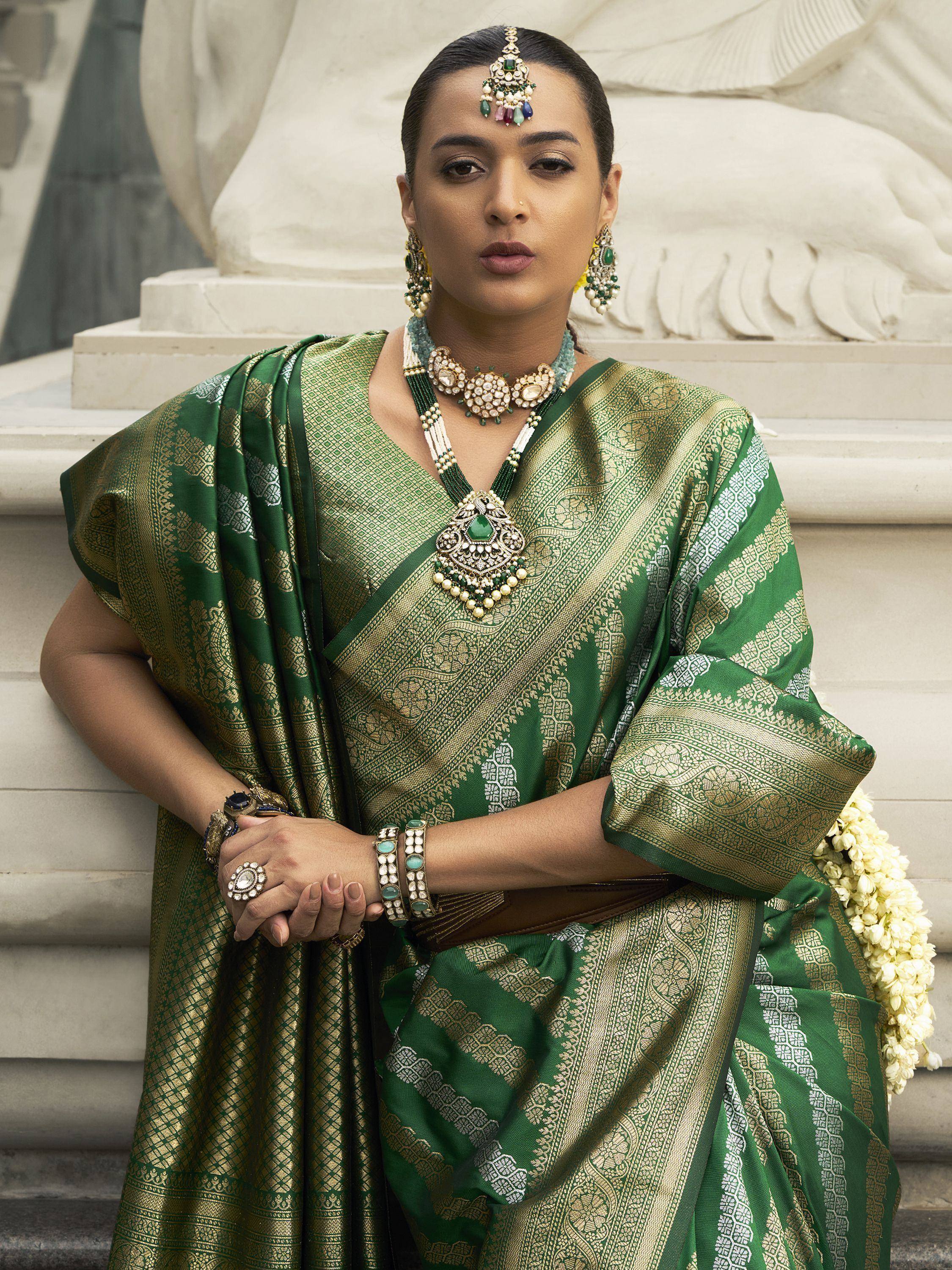 Elegant woman in green and gold ethnic saree with traditional jewelry, perfect for Indian weddings or festive occasions.