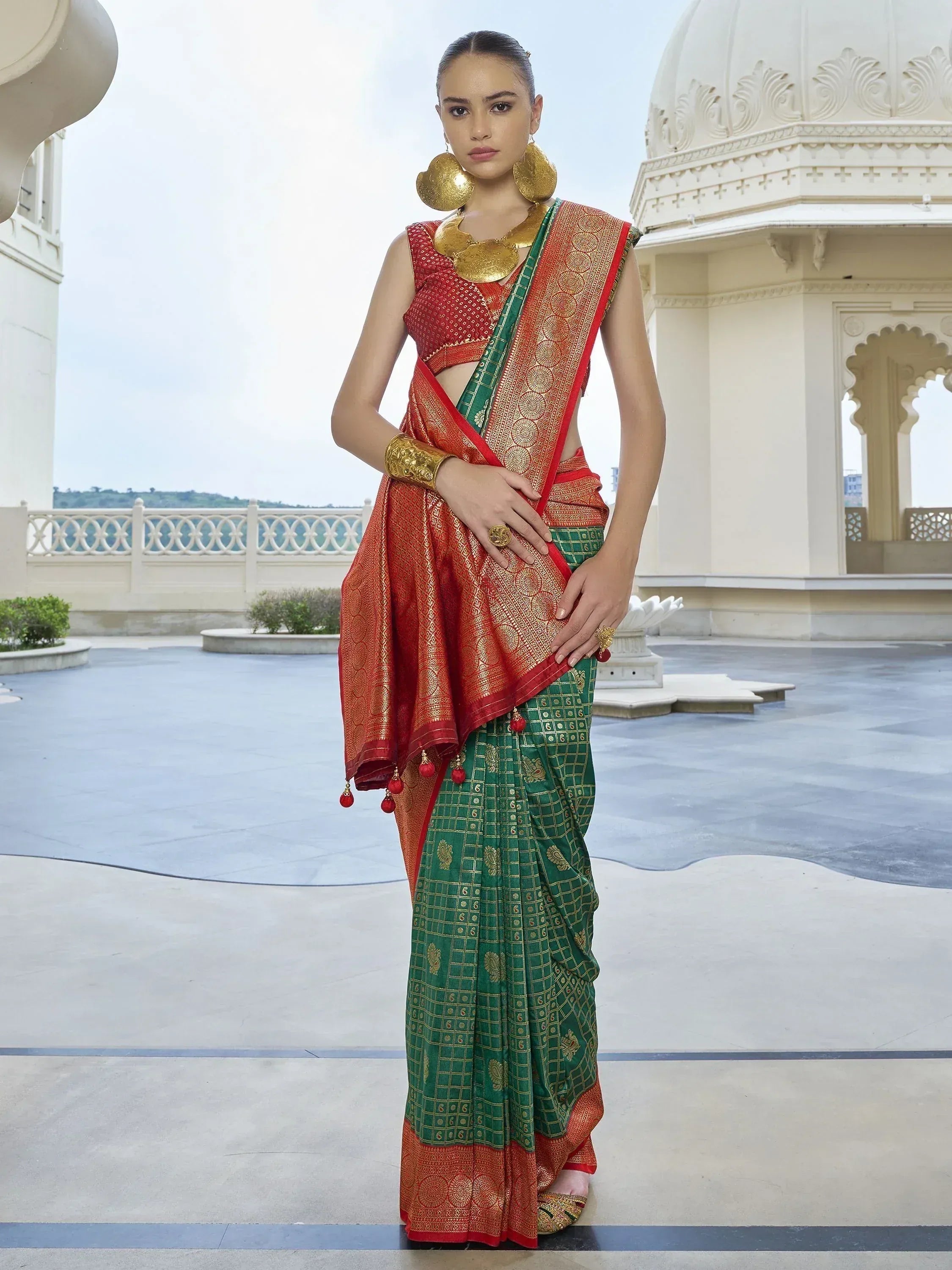 Woman in red and green designer saree with gold embroidery, traditional Indian ethnic wear