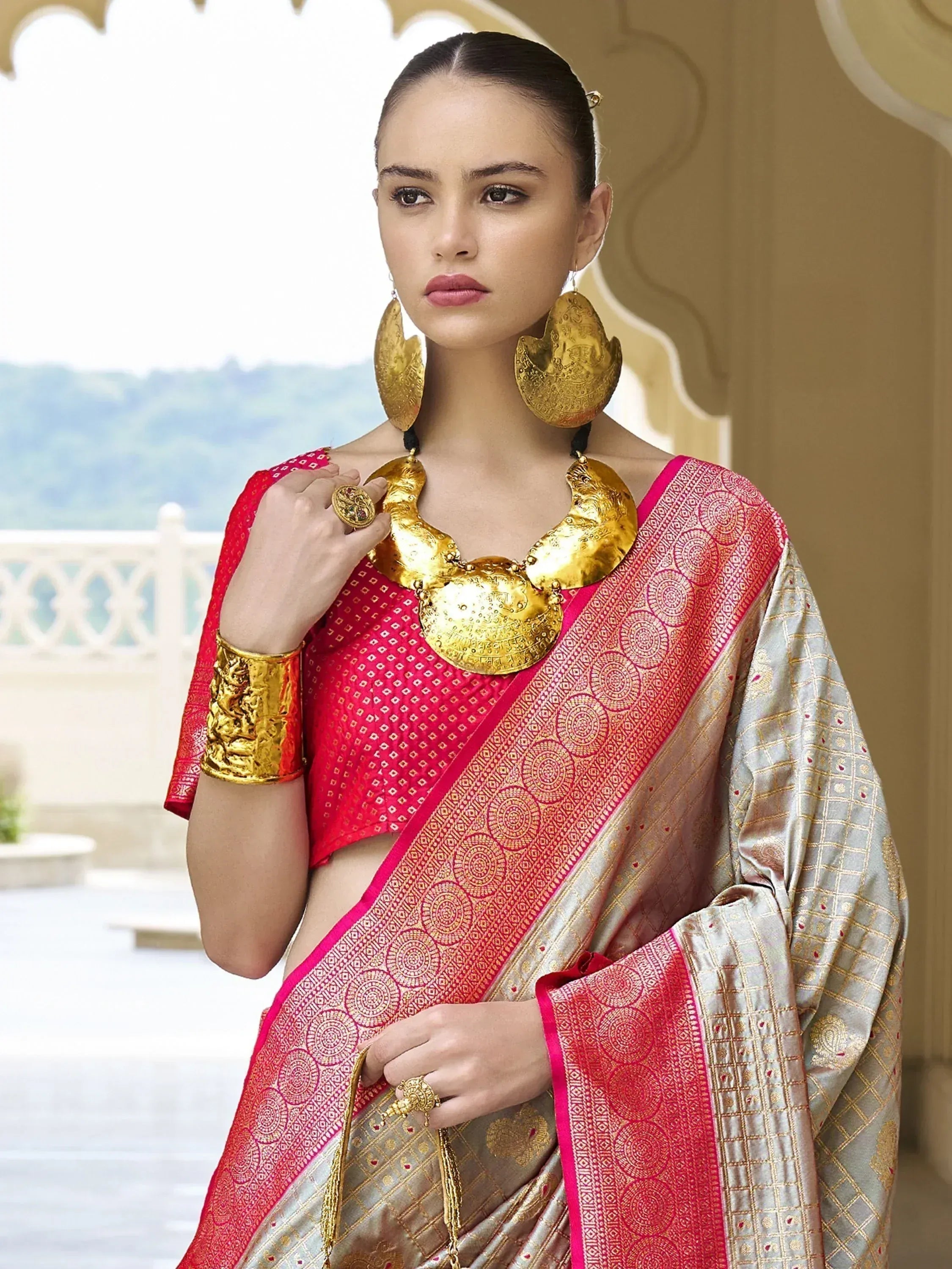 Woman in elegant pink and gold ethnic saree with traditional jewelry, perfect for Indian occasions