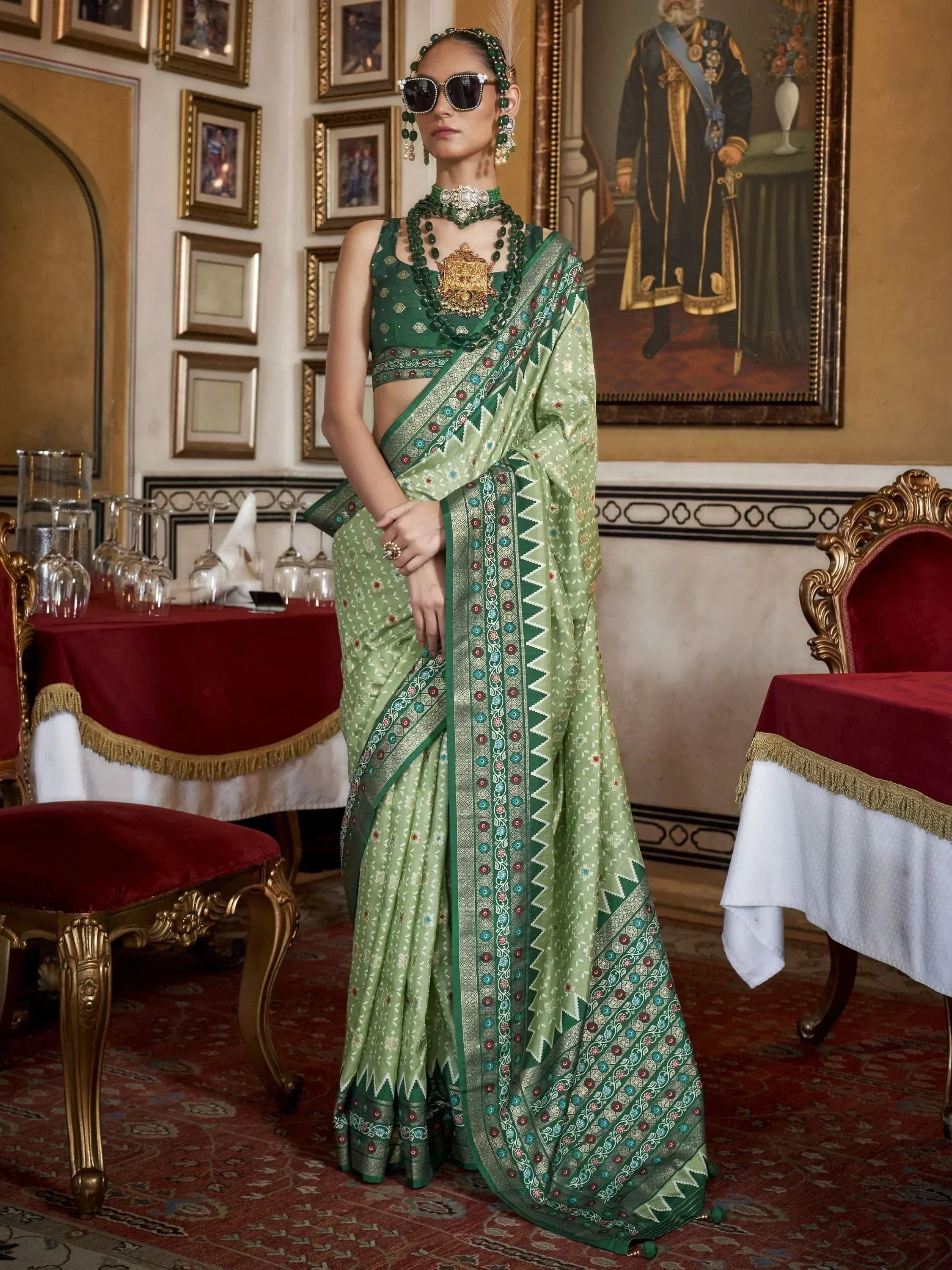 Green designer saree with intricate embroidery and matching blouse, styled with traditional jewelry for ethnic wear