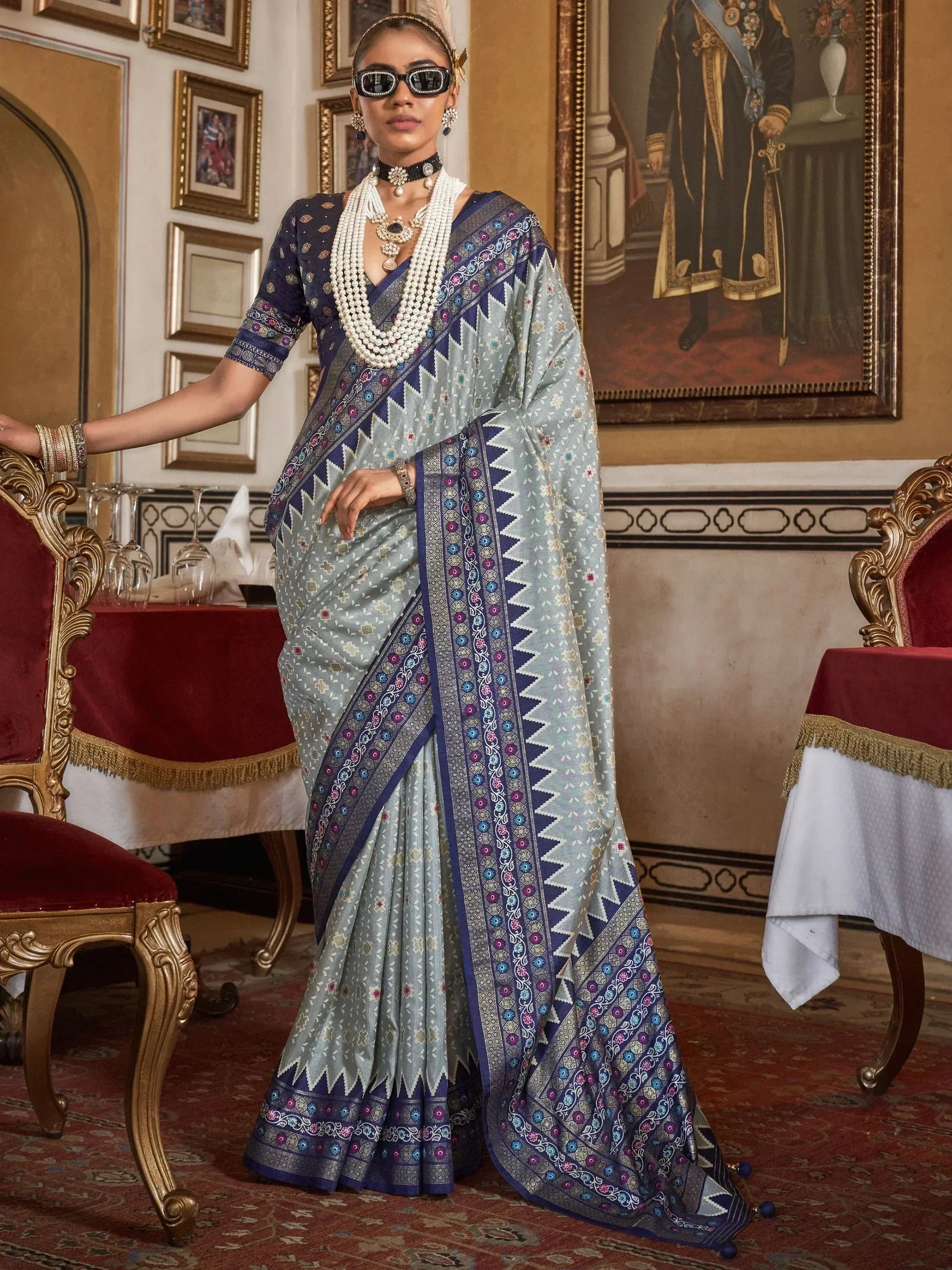 Stylish blue and grey printed saree with intricate border, paired with pearl jewelry for ethnic wear