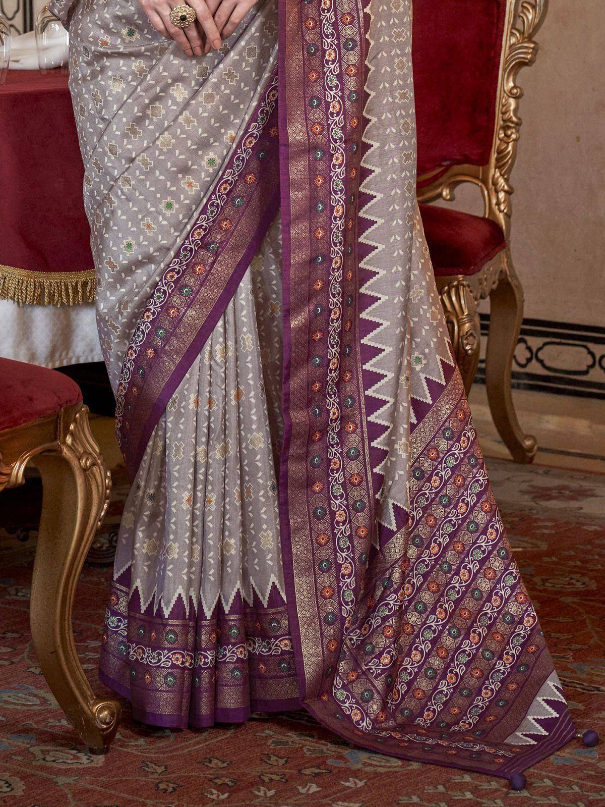 Elegant grey saree with purple border, floral motifs, and intricate embroidery, styled for Indian ethnic wear