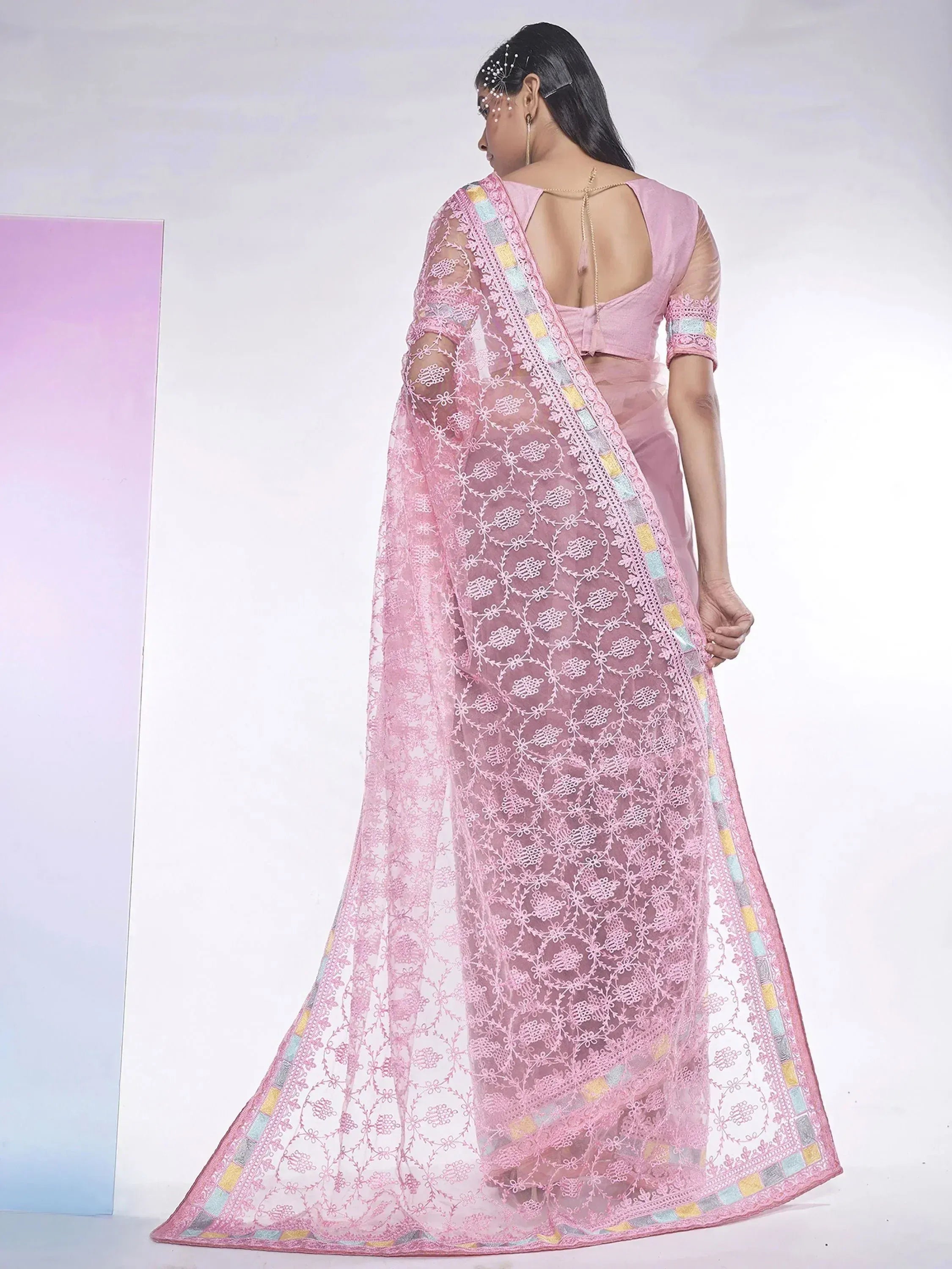 Pink embroidered saree with floral lace and colorful border, back view