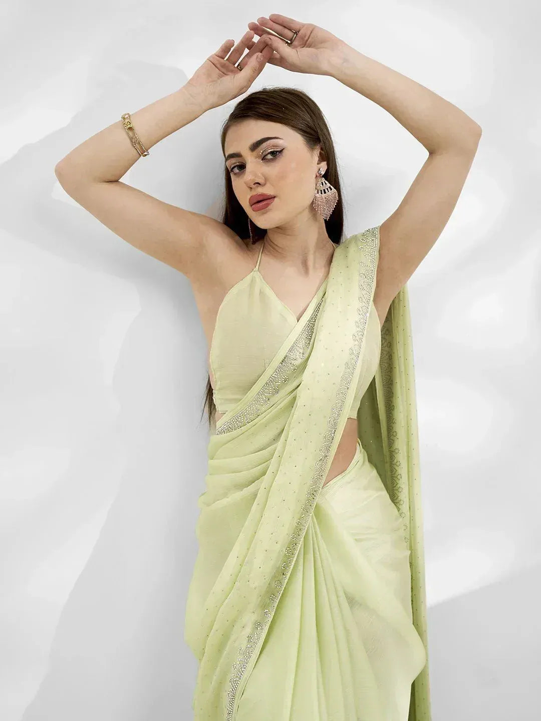 Light green designer saree with sequin border, paired with spaghetti strap blouse, perfect for ethnic occasions