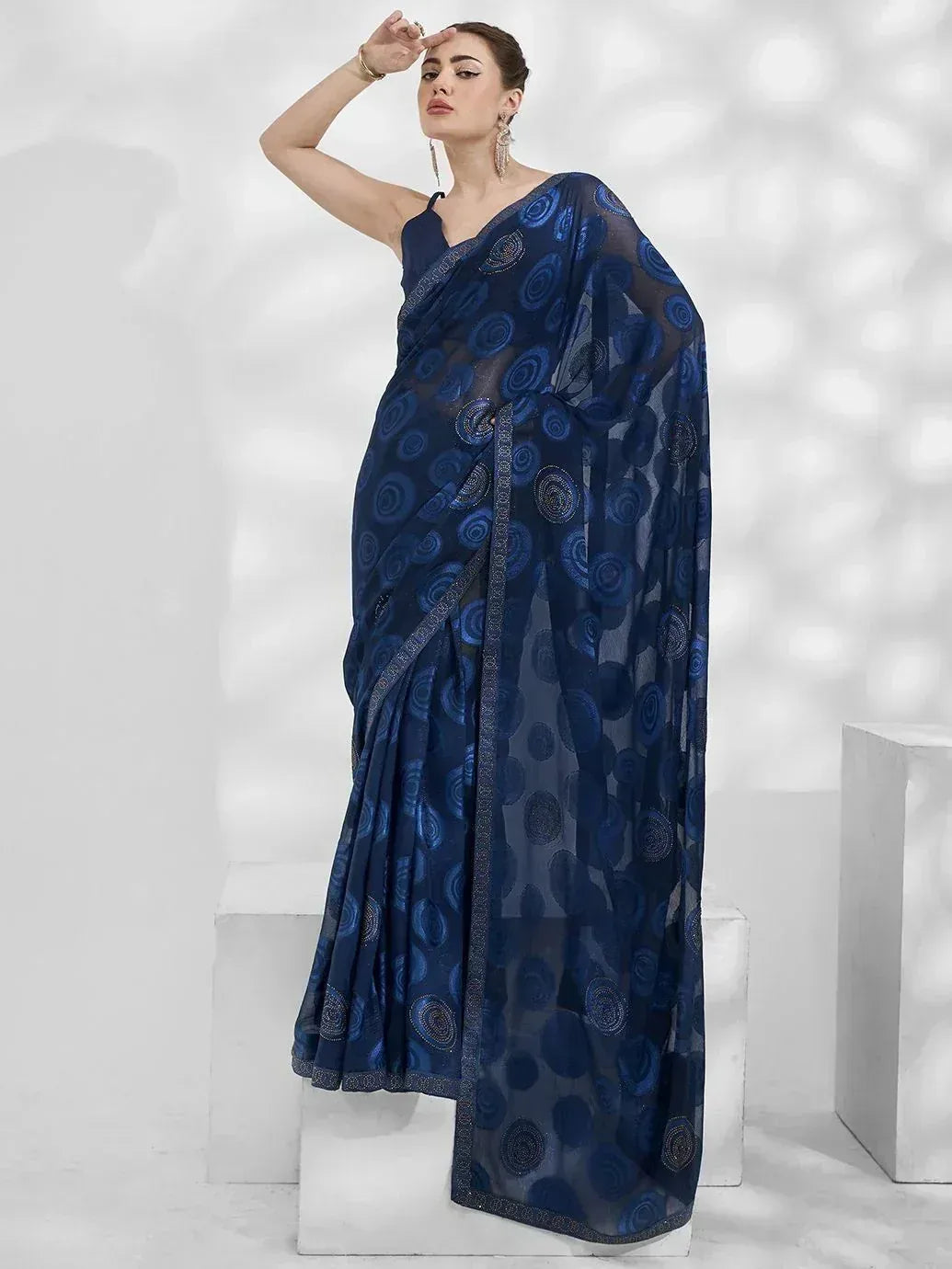 Navy blue embroidered saree with circular motifs, styled with sleeveless blouse for ethnic wear