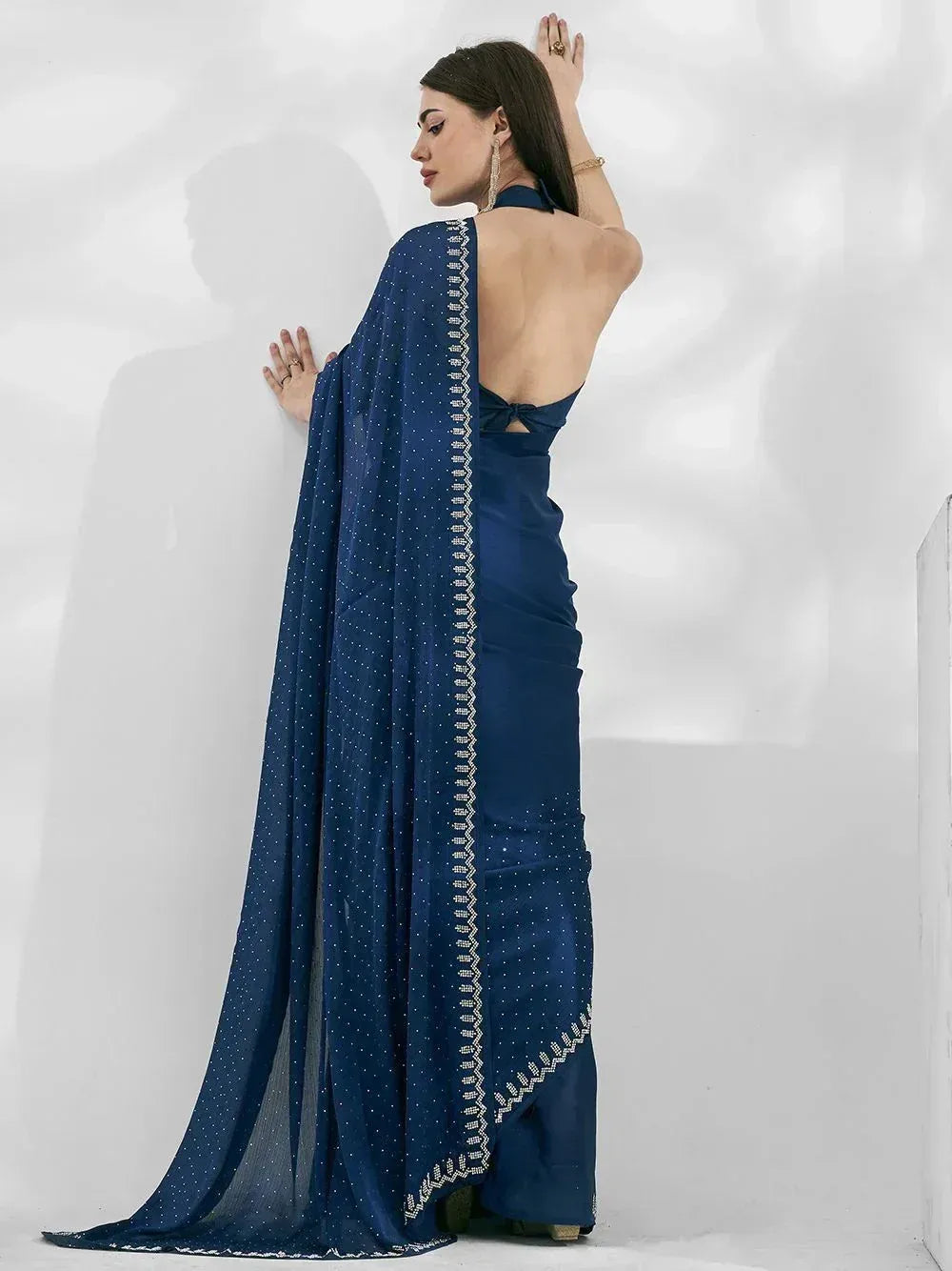 Navy blue designer saree with backless blouse and embellished border, perfect for ethnic occasions