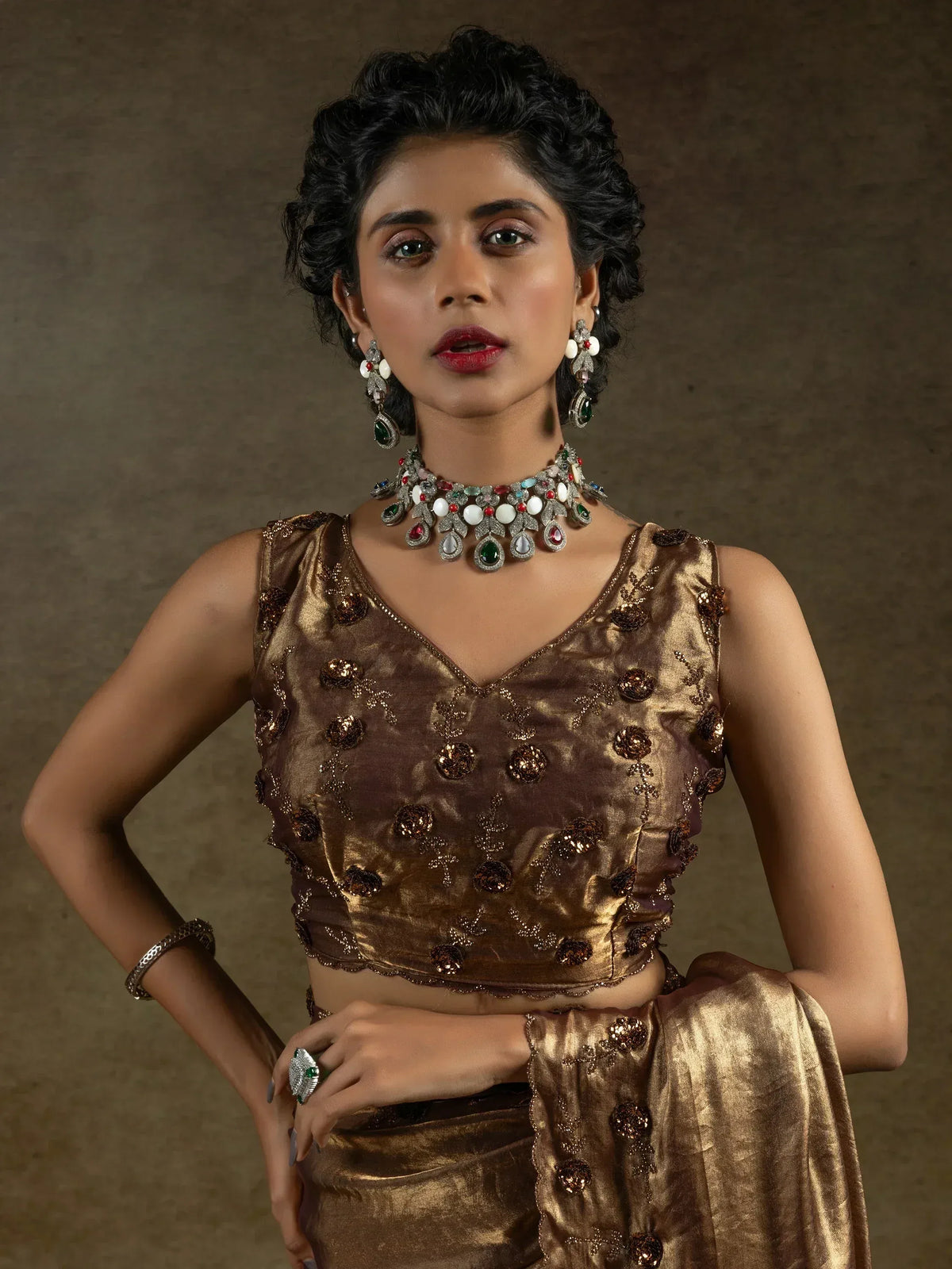 Elegant woman in gold embroidered lehenga choli with colorful jewelry