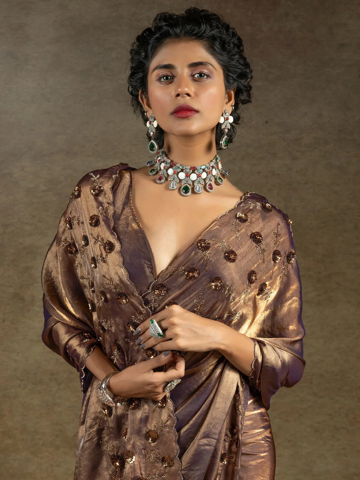 Elegant woman in designer ethnic saree with intricate embroidery and gemstone jewelry