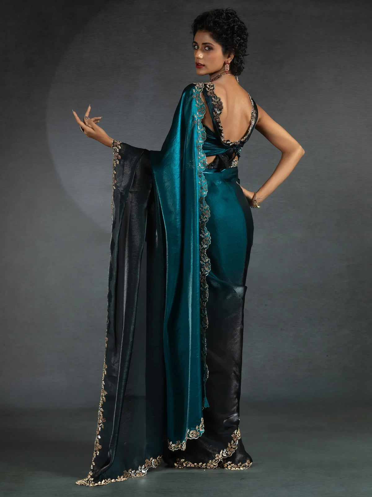 Elegant teal and black saree with gold embroidery, perfect for ethnic occasions.