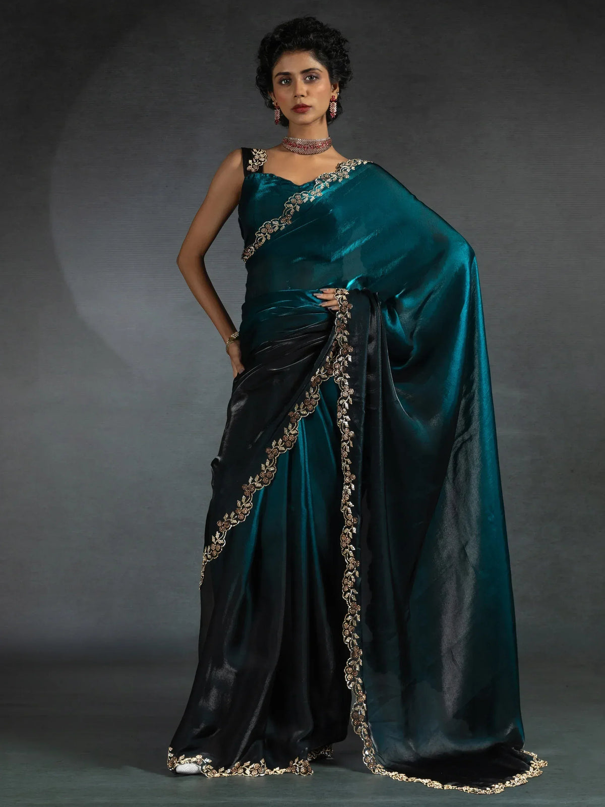 Elegant teal and black saree with gold embroidery, perfect for ethnic occasions.