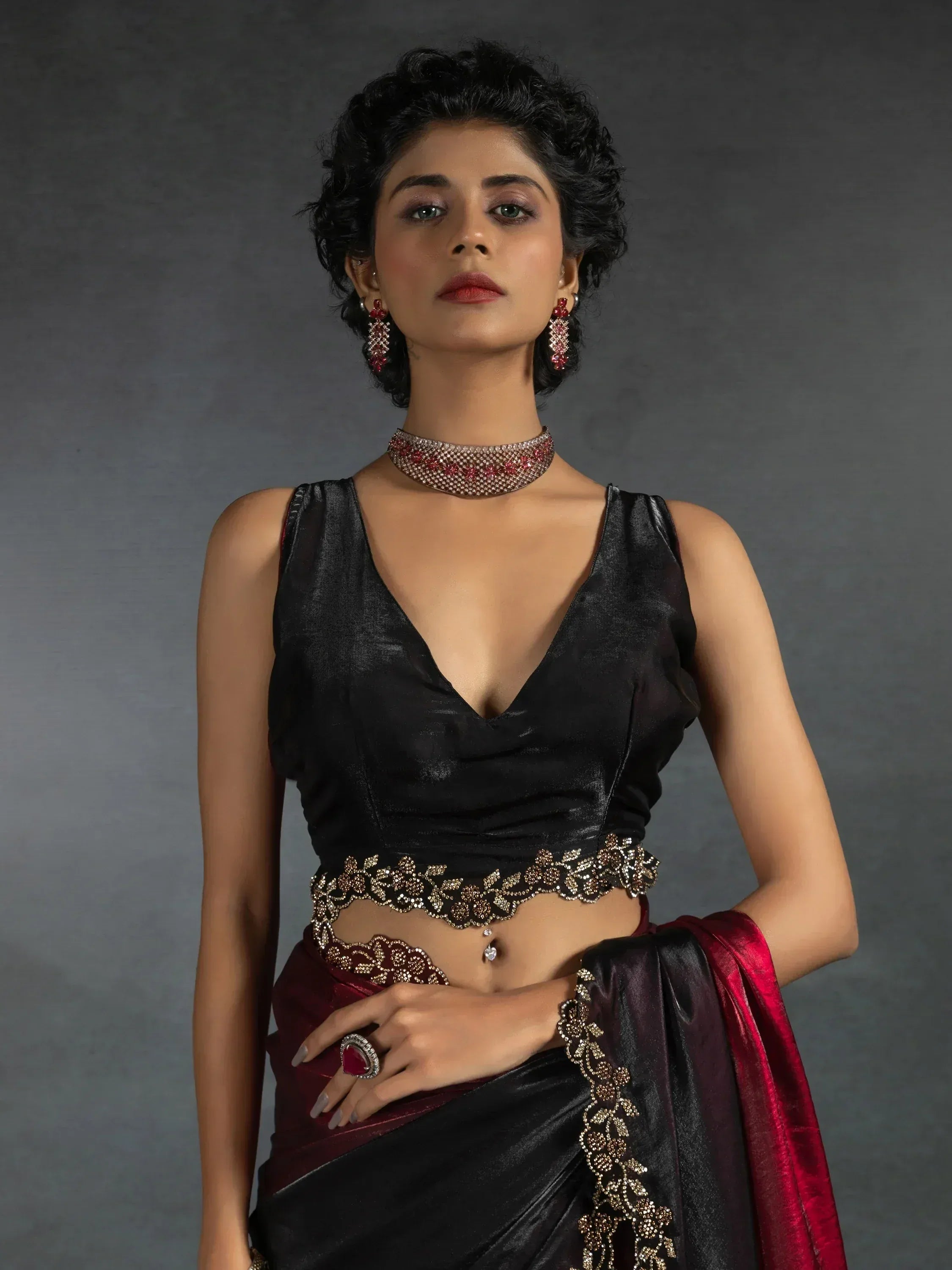 Elegant black and maroon saree with gold embroidery, paired with statement jewelry for ethnic wear.