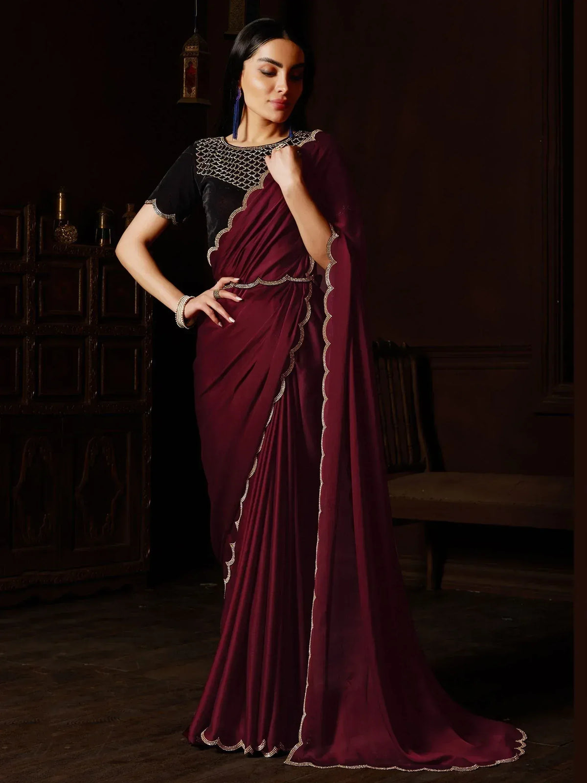 Elegant maroon saree with gold scalloped embroidery, paired with black velvet blouse, perfect for Indian ethnic occasions.