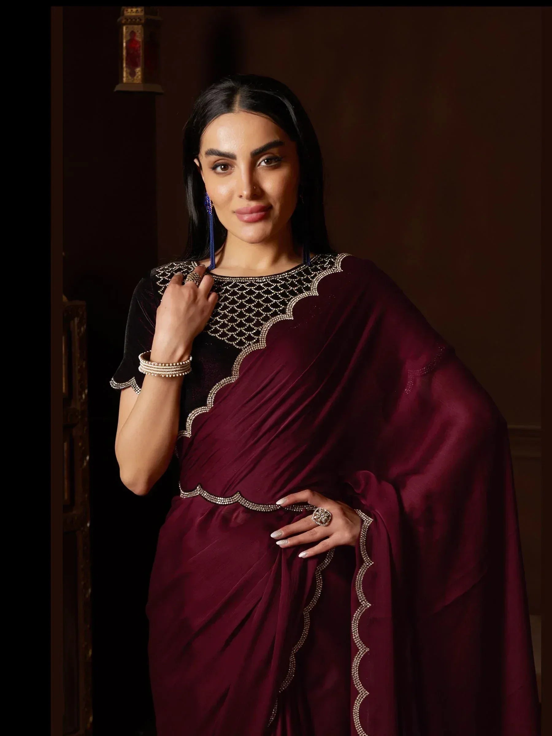 Elegant maroon saree with black velvet blouse, intricate gold embroidery, and statement jewelry for Indian ethnic wear.