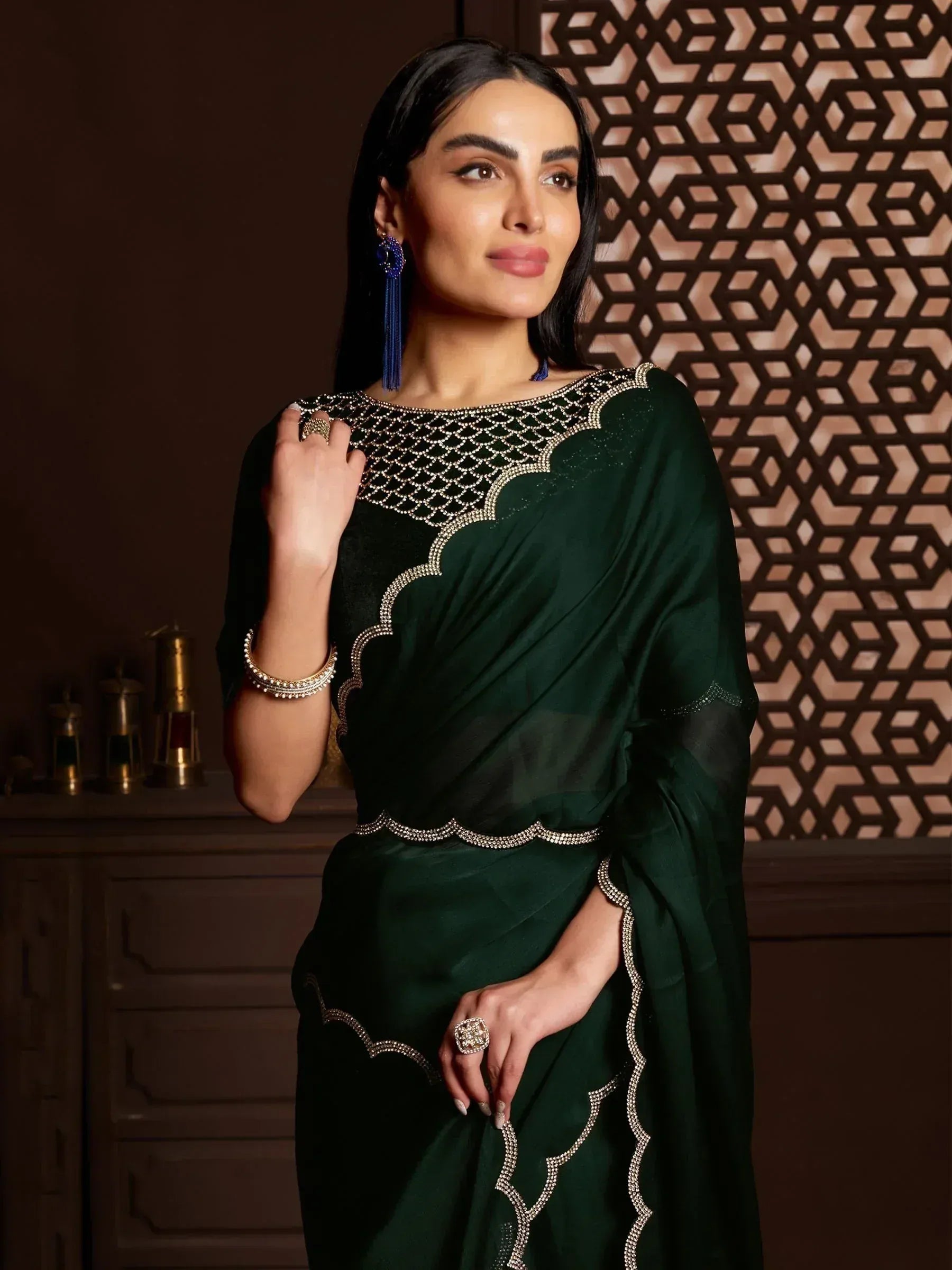 Emerald green designer saree with intricate gold embroidery and scalloped detailing, perfect for Indian ethnic wear.