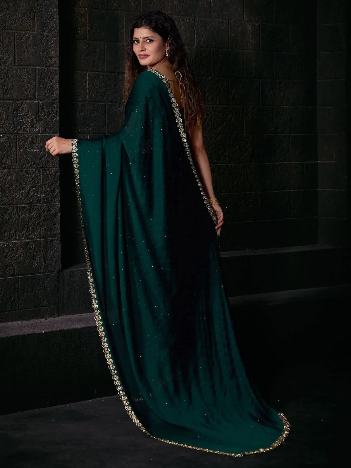 Emerald green ethnic gown with gold embroidery, perfect for Indian weddings and festive occasions