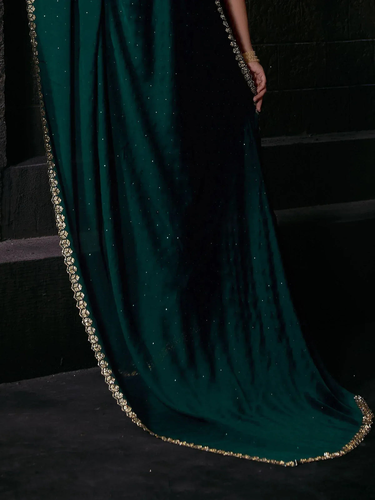 Emerald green velvet ethnic gown with gold embroidery and sequin detailing, perfect for Indian festive occasions.