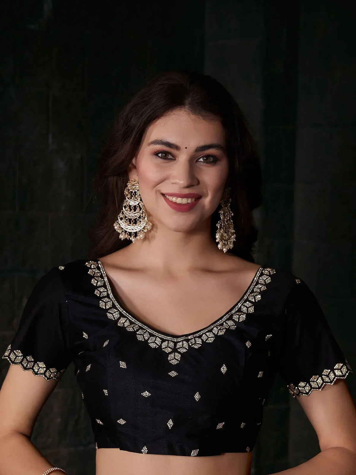 Black embroidered blouse with gold detailing, paired with statement earrings, perfect for Indian ethnic wear.