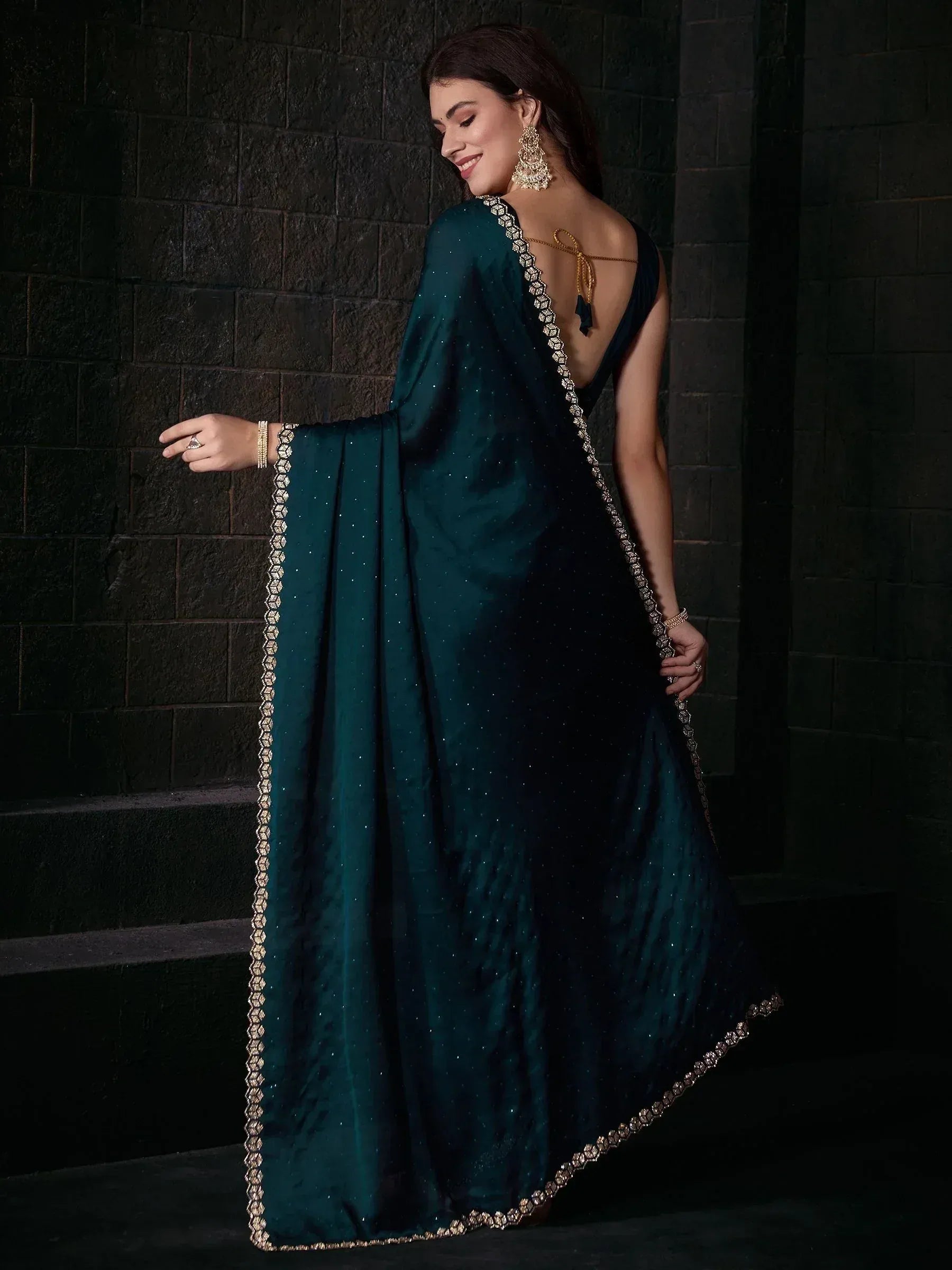 Elegant teal saree with gold embroidery and open back, perfect for Indian ethnic wear occasions