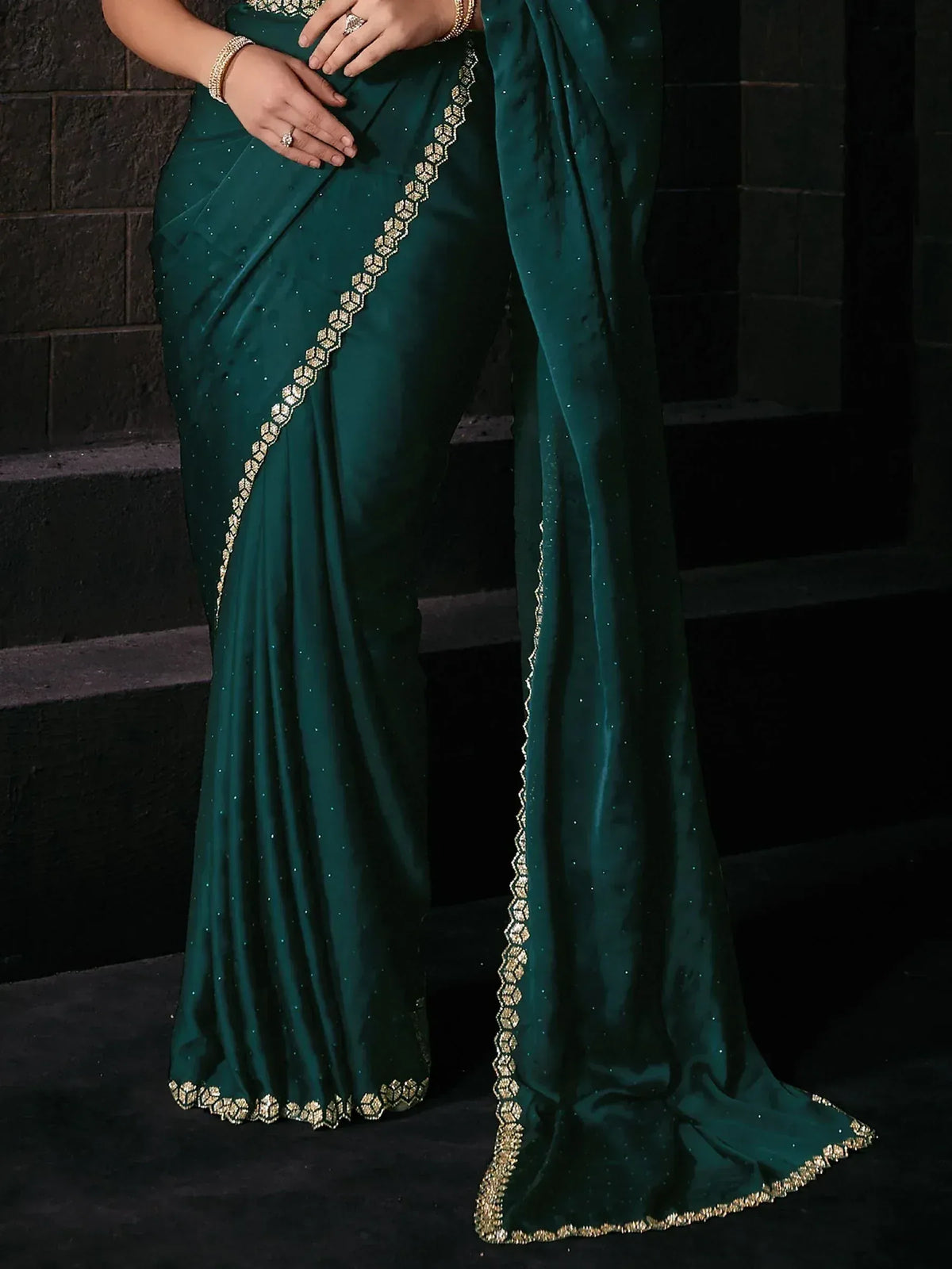 Emerald green saree with gold geometric border and subtle sequin detailing, perfect for ethnic occasions.