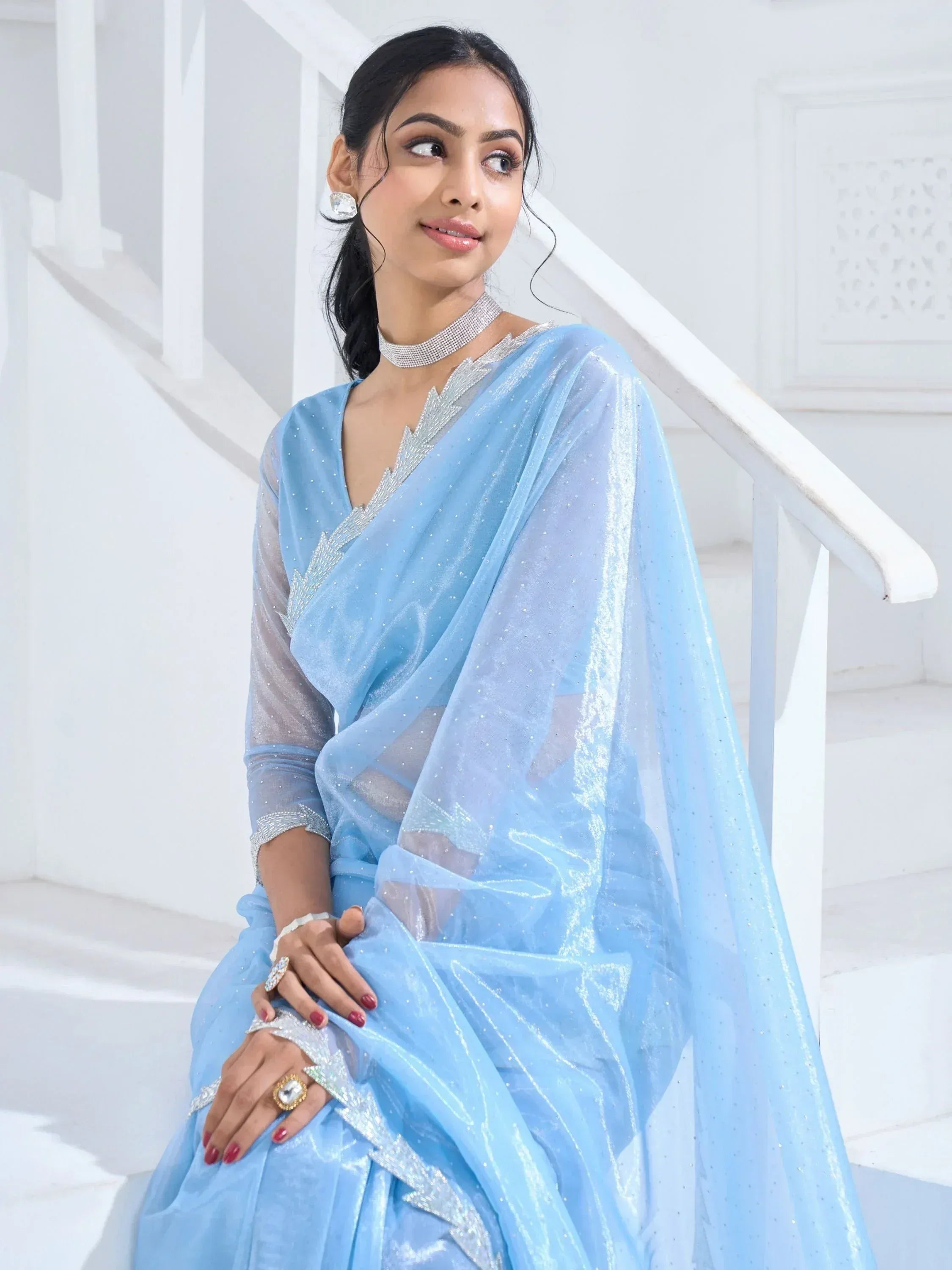 Woman in light blue embroidered saree with silver embellishments, styled for Indian ethnic occasions