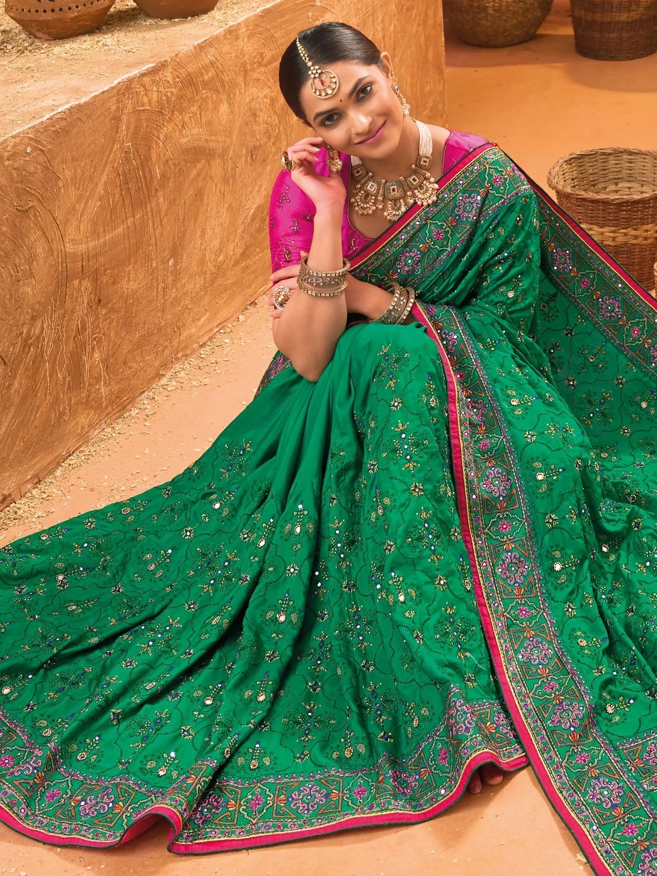 Woman in green embroidered saree with pink blouse, traditional Indian ethnic wear, festive occasion dress