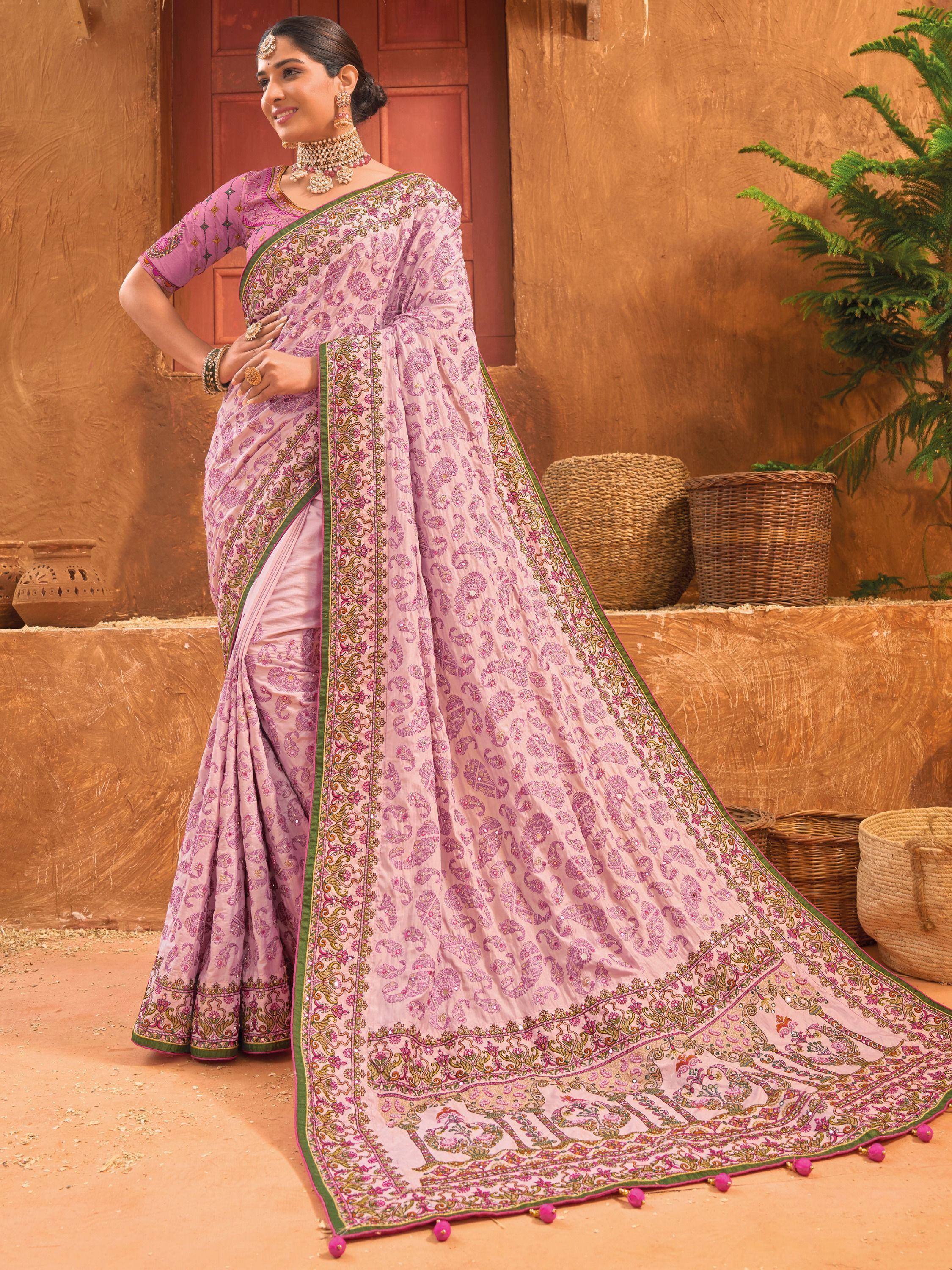 Elegant pink embroidered saree with paisley print and green border, styled with traditional jewelry for ethnic wear.
