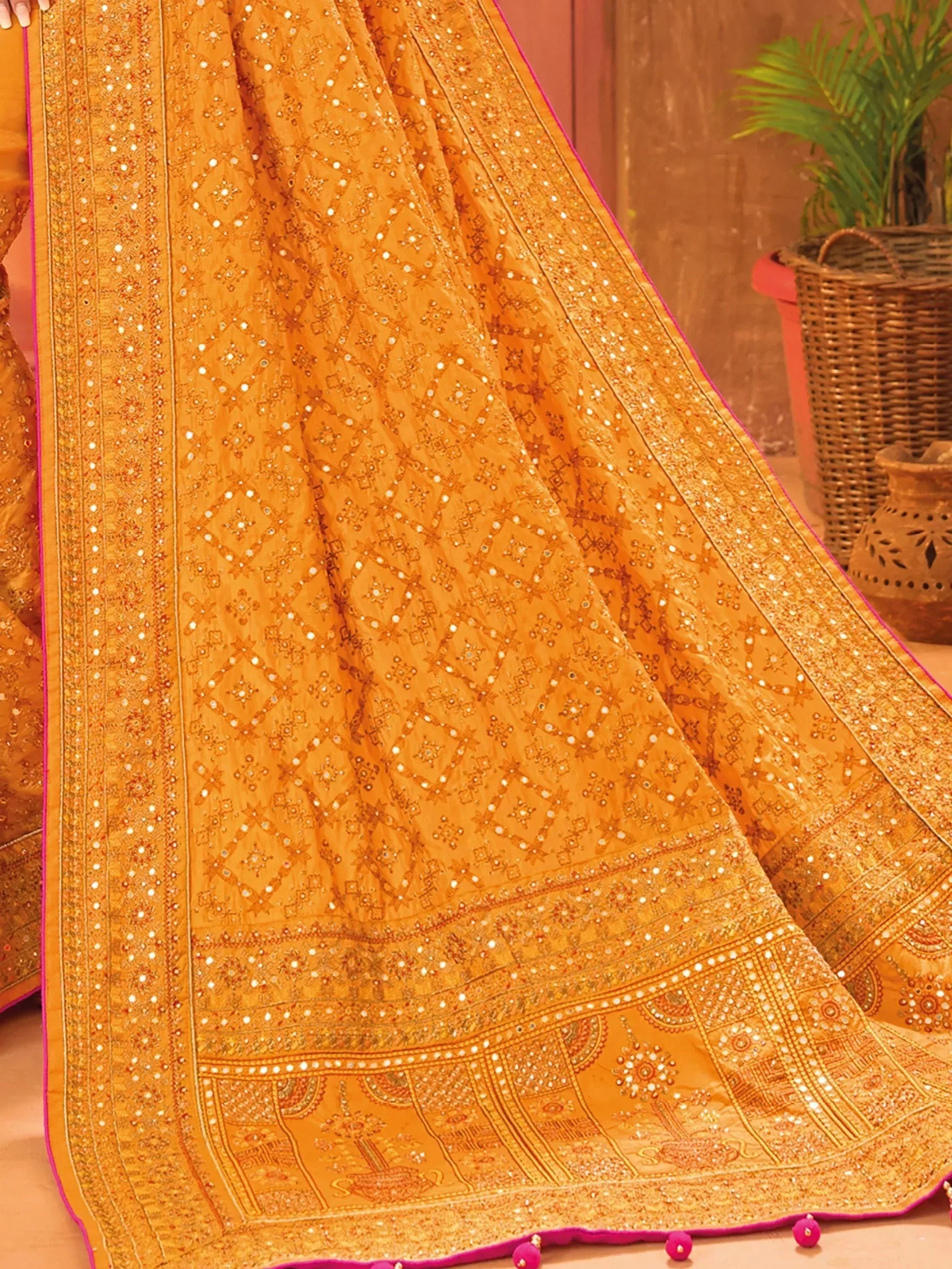 Golden ethnic lehenga with mirror work and pink border, traditional Indian bridal wear