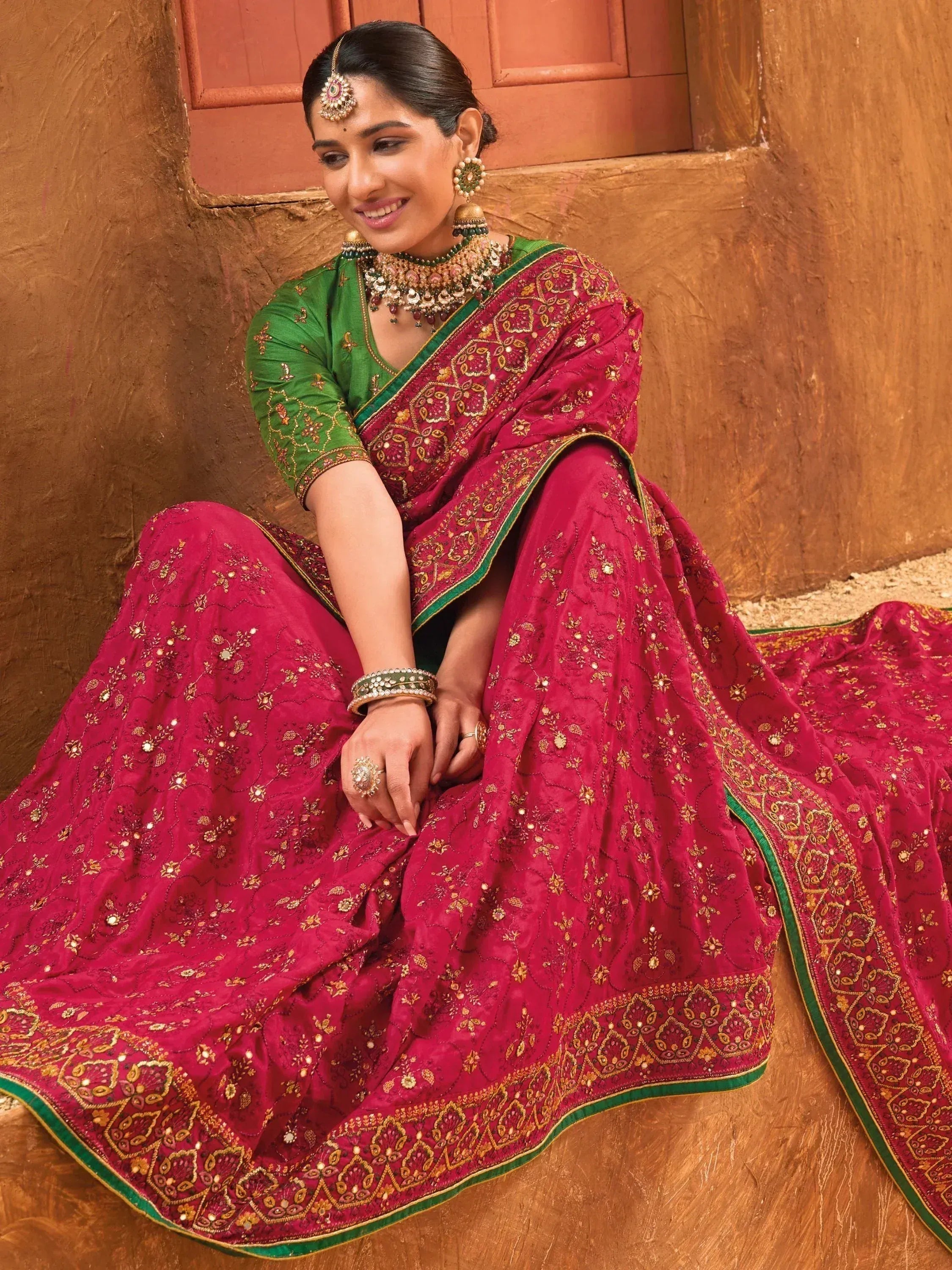 Woman in maroon and green embroidered lehenga choli with traditional jewelry, Indian ethnic wear