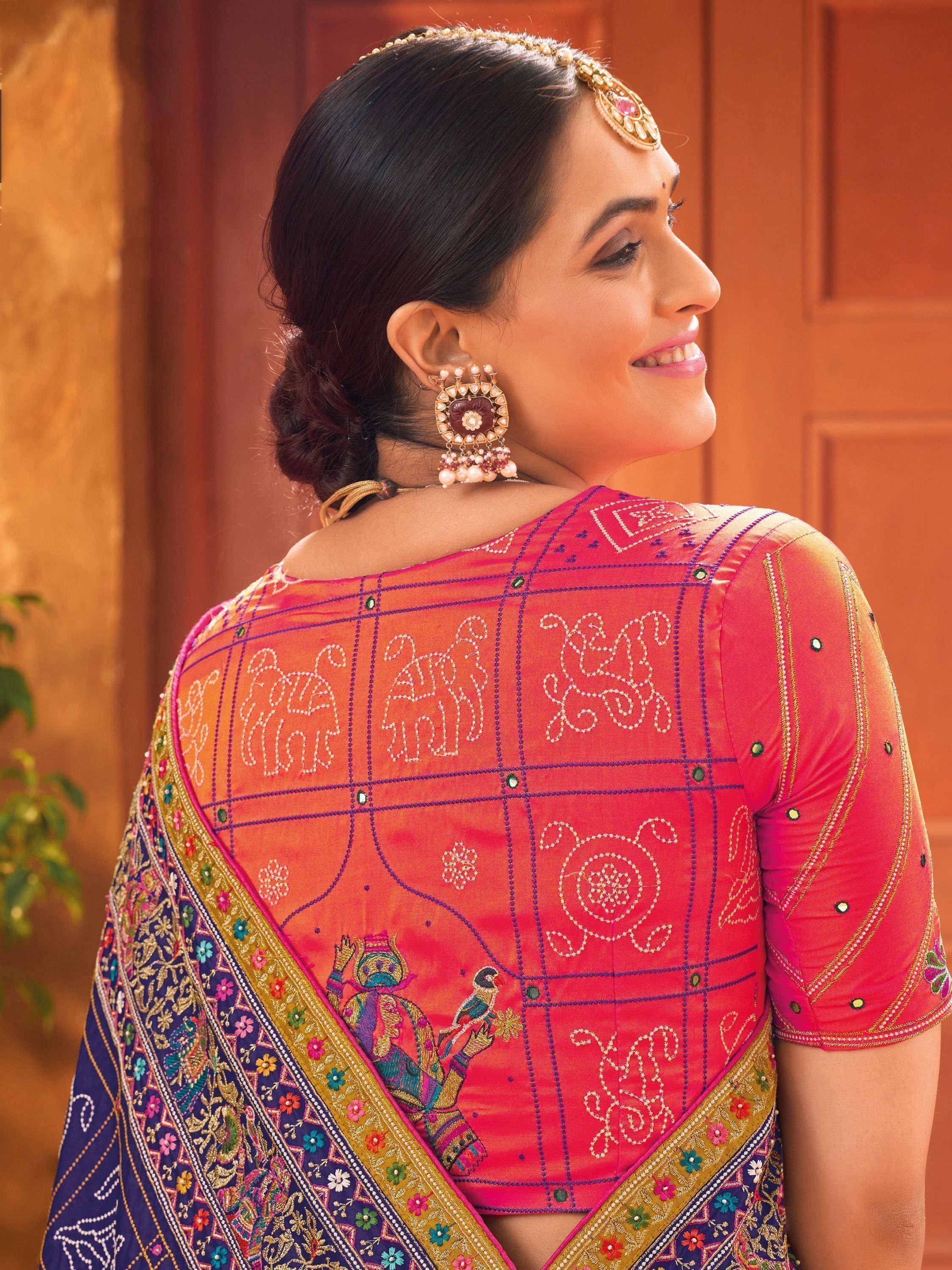 Woman in vibrant pink embroidered saree with elephant motifs, traditional Indian ethnic wear
