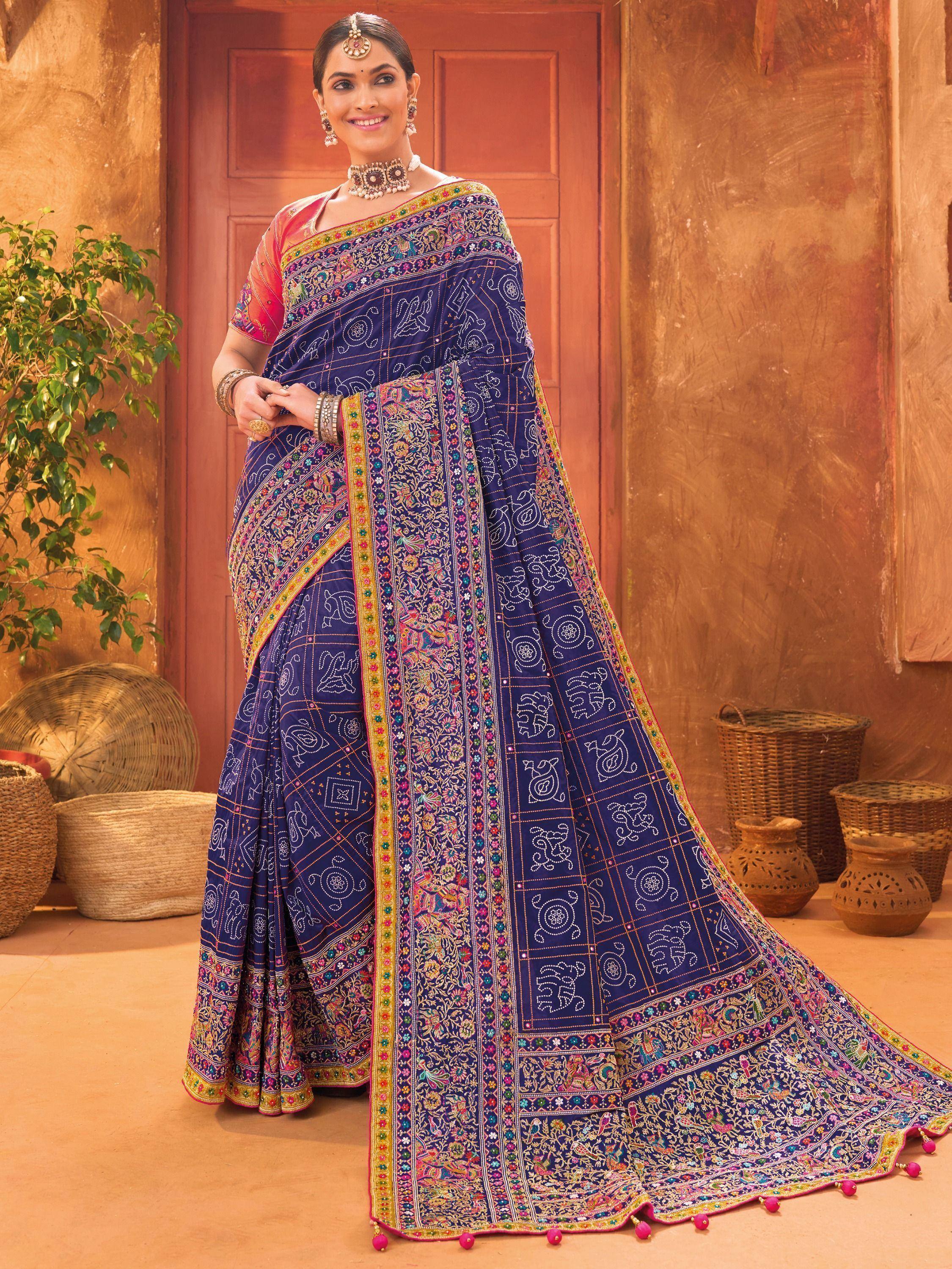 Woman in navy blue embroidered saree with colorful motifs, traditional Indian ethnic wear