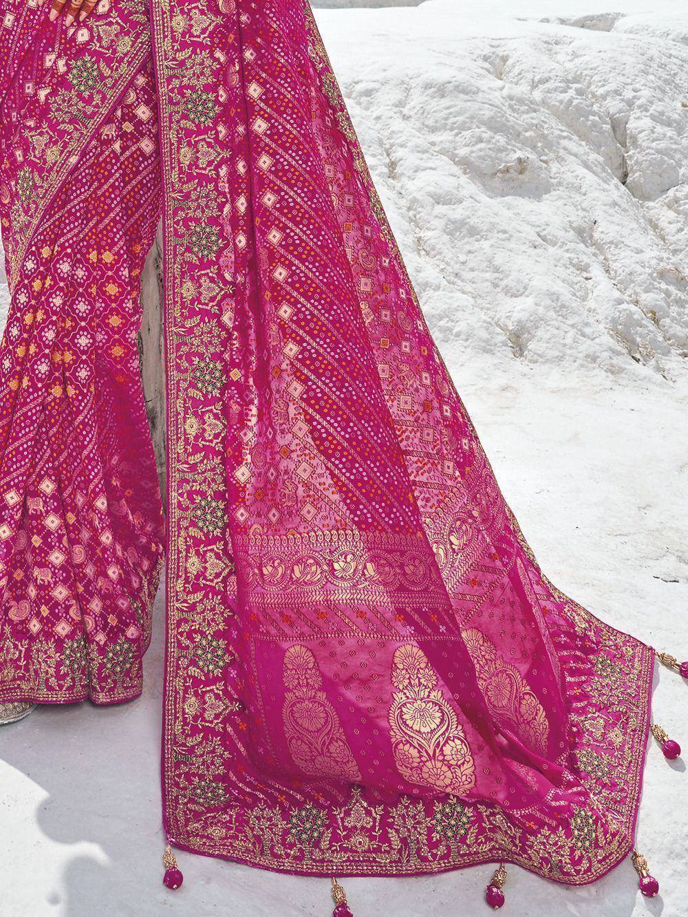 Fuchsia pink ethnic saree with gold embroidery and tassels, perfect for Indian weddings and festive occasions.