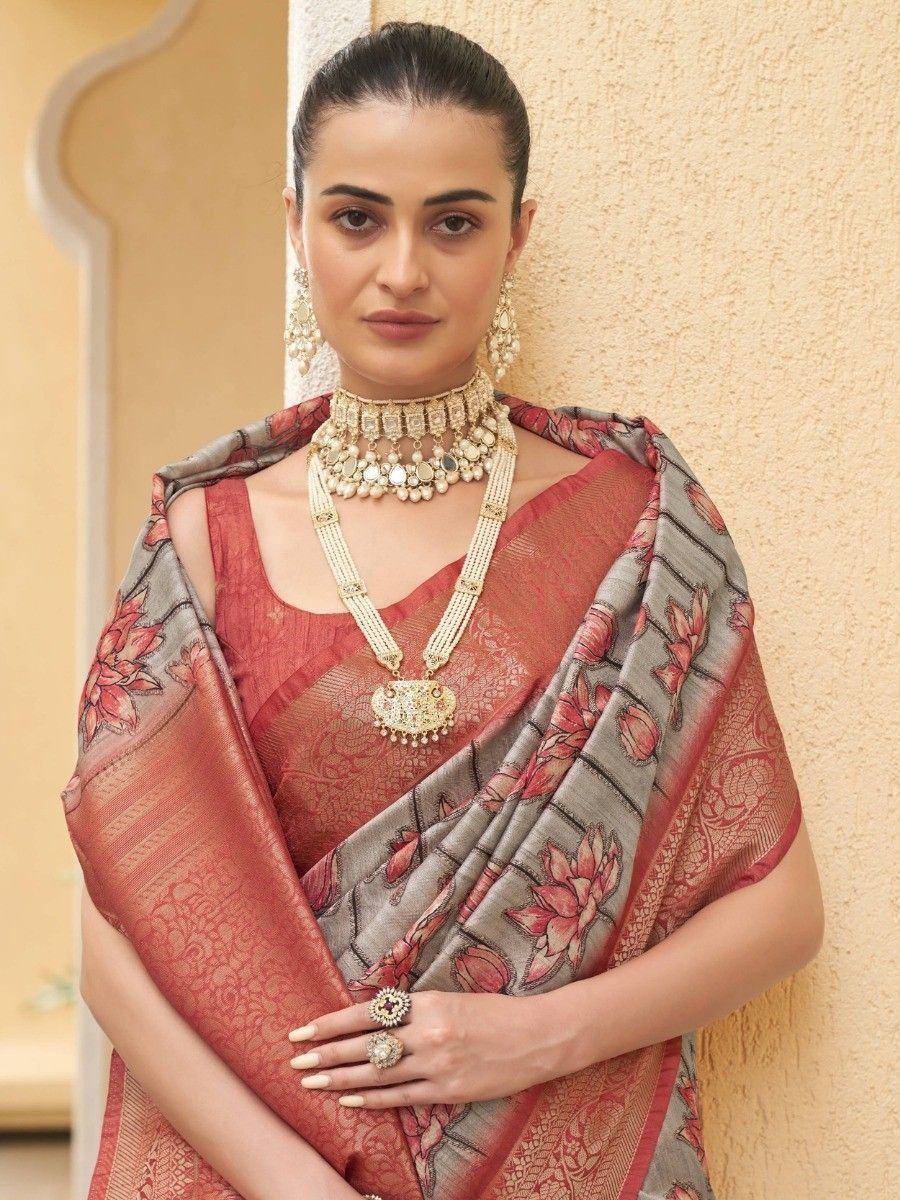 Woman in elegant red and grey floral saree with traditional jewelry, perfect for Indian ethnic occasions.
