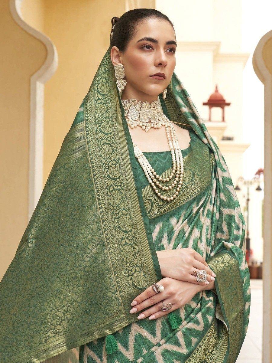 Elegant green ethnic saree with intricate gold embroidery and pearl jewelry, perfect for Indian occasions.
