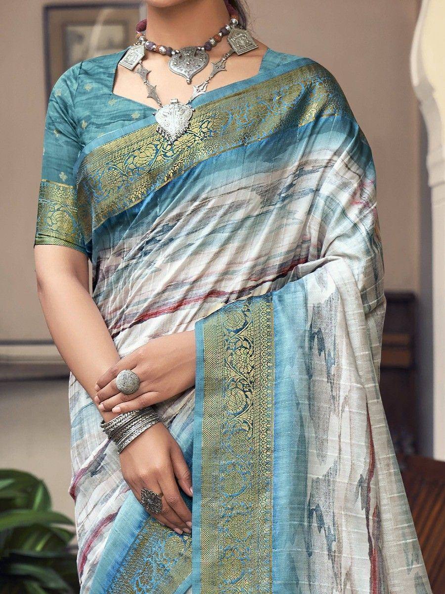 Blue and gold designer saree with intricate border, paired with silver ethnic jewelry for traditional Indian wear