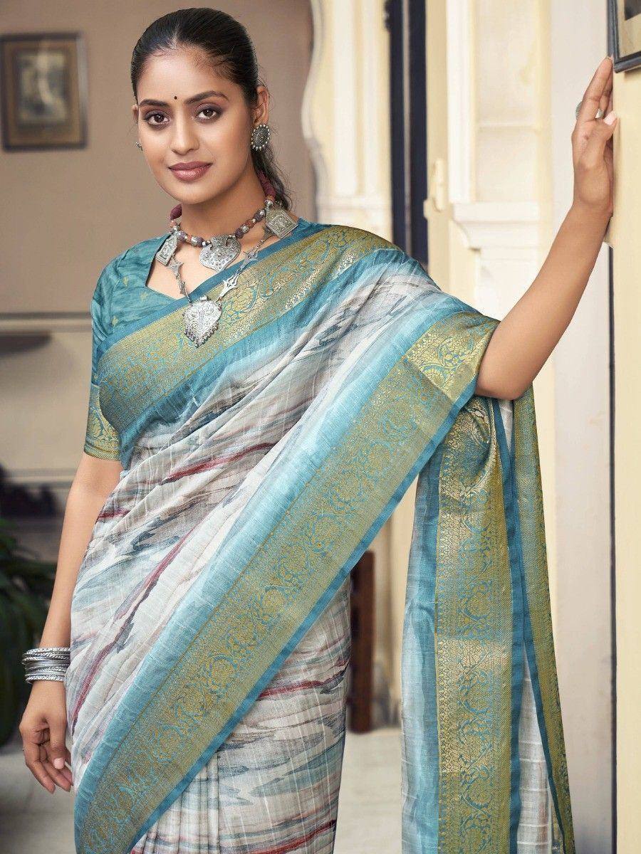 Woman in elegant blue and gold designer saree with intricate border, perfect for ethnic occasions.