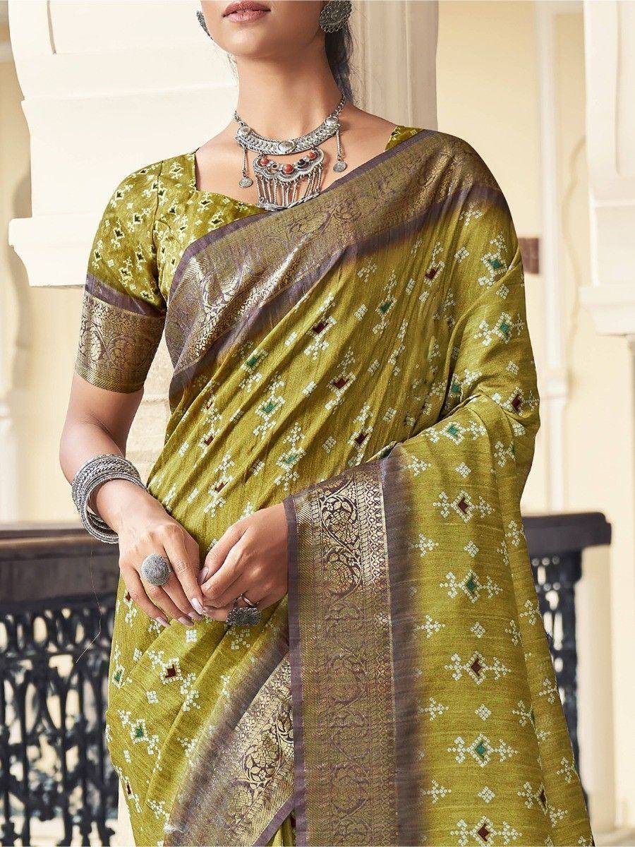 Olive green designer saree with geometric print and embroidered border, paired with traditional jewelry
