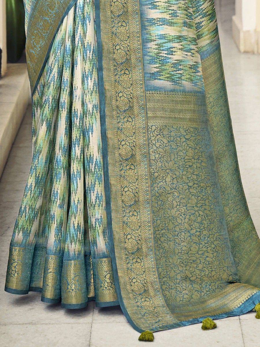 Elegant blue-green ikat saree with intricate gold zari border and tassels, perfect for ethnic occasions