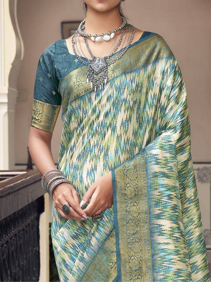 Teal and gold ikat saree with intricate border, paired with statement silver jewelry for ethnic wear