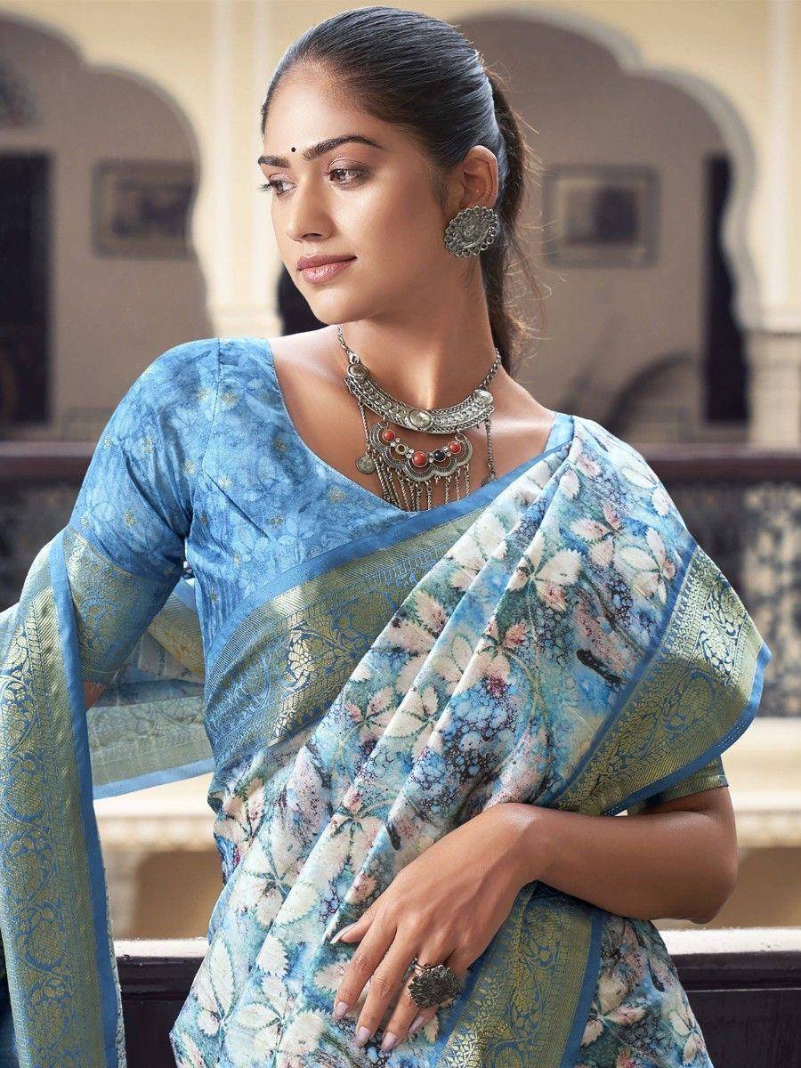 Blue floral printed saree with gold border, styled with ethnic jewelry for traditional Indian wear