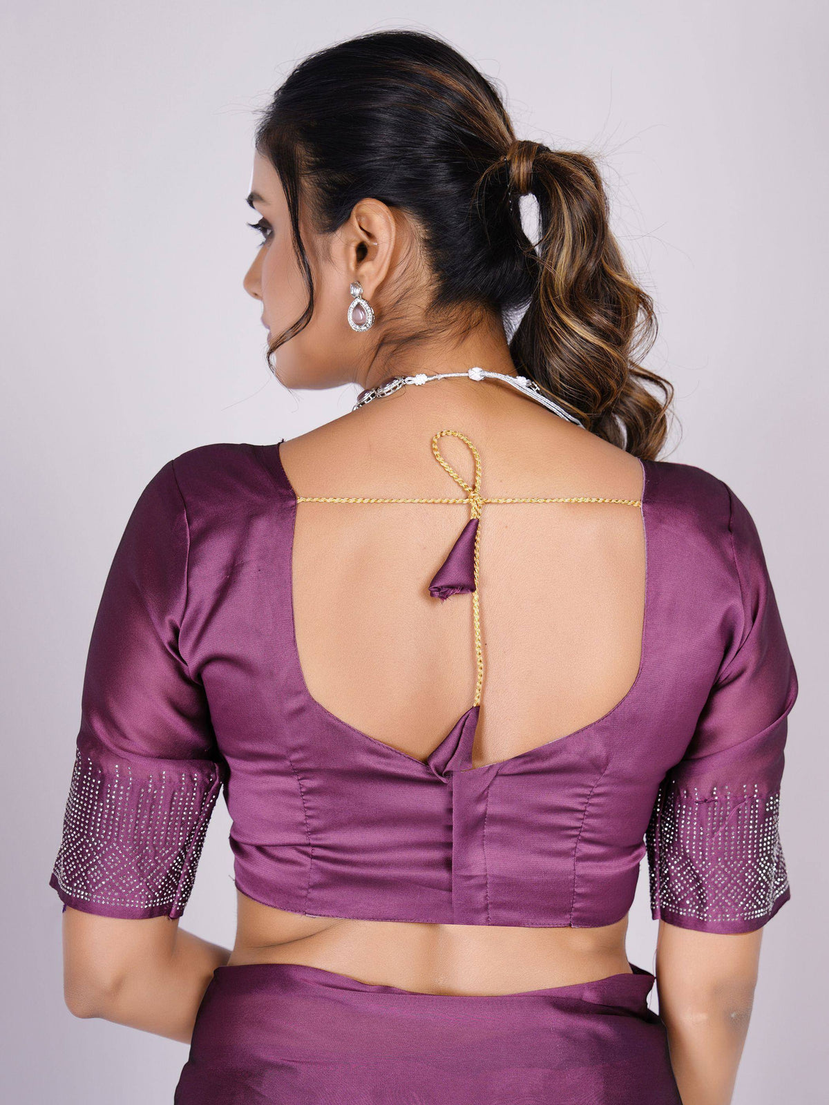 Purple saree blouse with open back, gold chain tie, and crystal-embellished sleeves