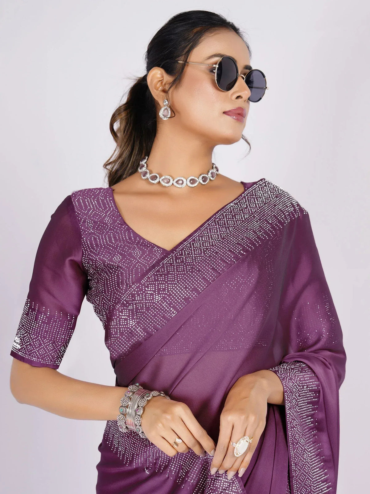 Purple sequin saree with V-neck blouse, styled with sunglasses and jewelry for ethnic wear