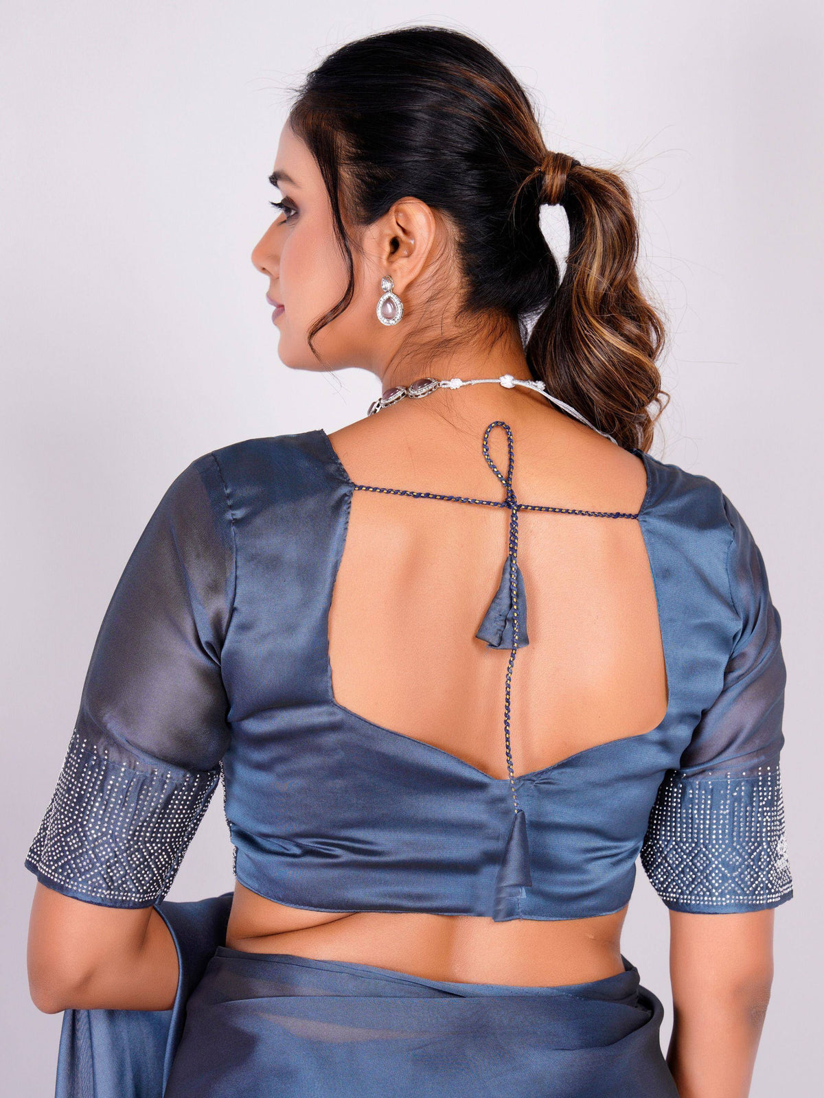Blue satin saree blouse with open back, crisscross tie, and embellished sleeves for ethnic wear